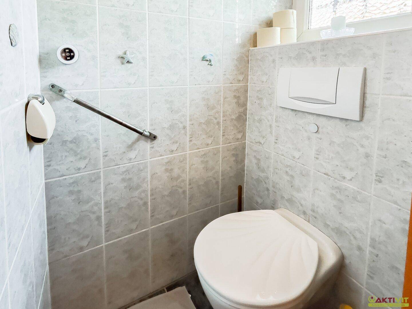 Kleines WC mit Fliesen und Wand-WC, funktional und sauber gestaltet.