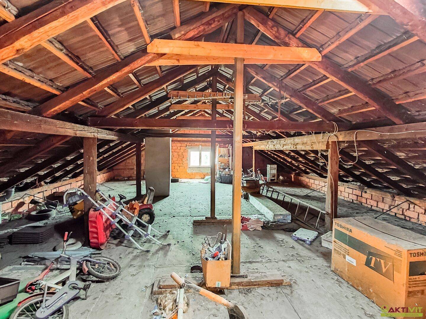 Geräumiger Dachboden mit sichtbaren Holzbalken, bietet viel Stauraum und Ausbaupotenzial.