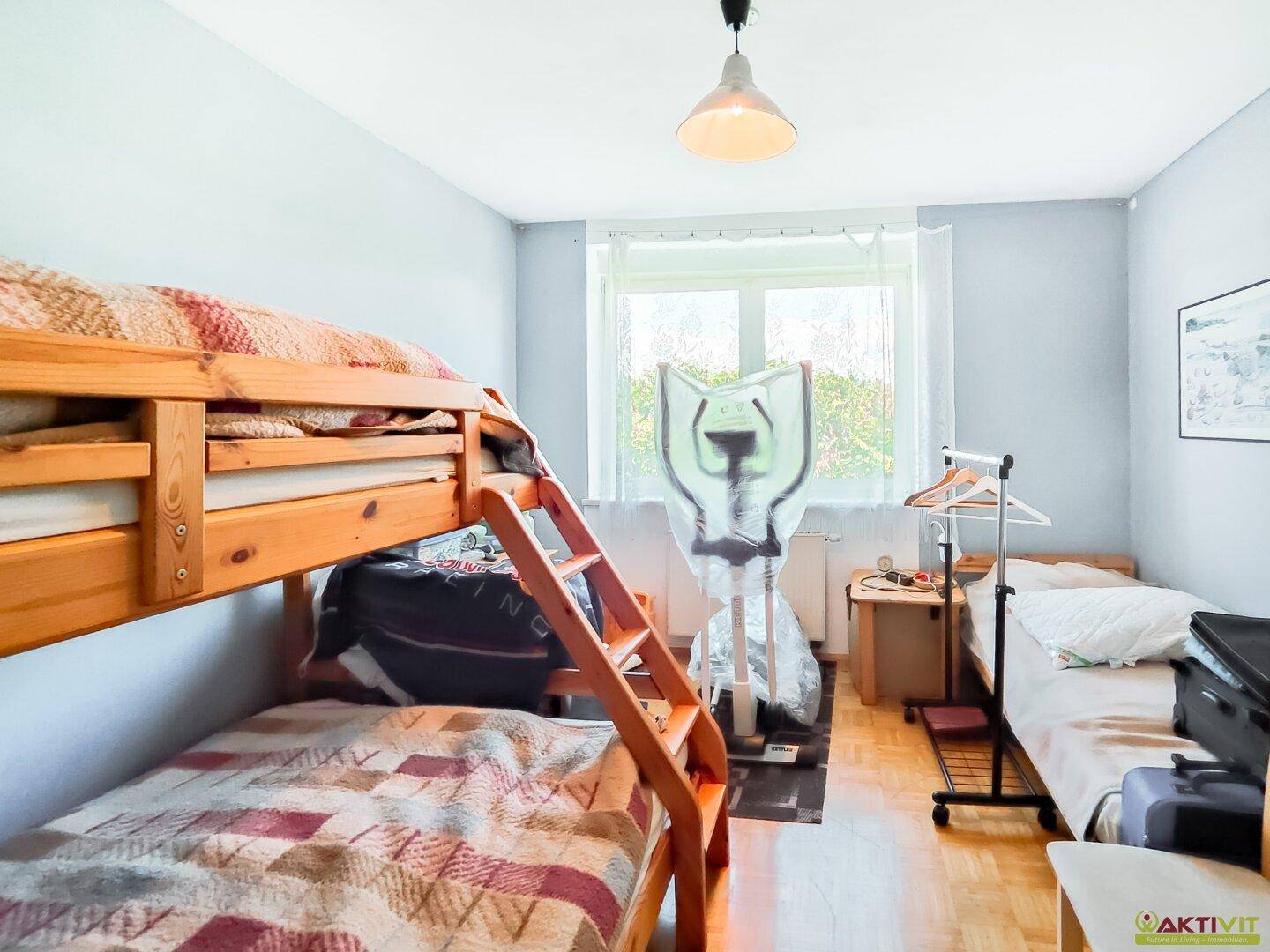 Kinderzimmer mit Etagenbett und Fenster, bietet Platz für mehrere Kinder oder Gäste.
