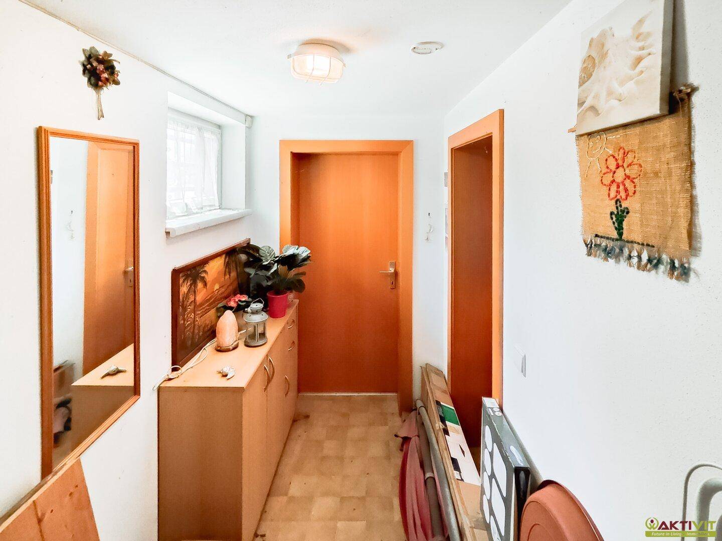 Kellerflur mit Fenster und praktischen Ablagemöglichkeiten, ideal für zusätzlichen Stauraum.
