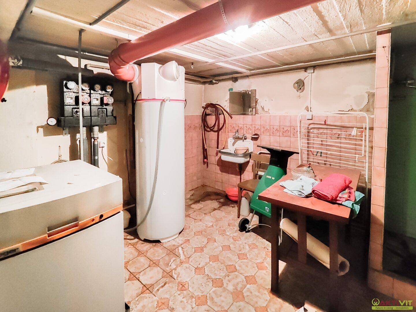 Hauswirtschaftsraum im Keller mit Heizungsanlage und Waschbecken, funktional eingerichtet.