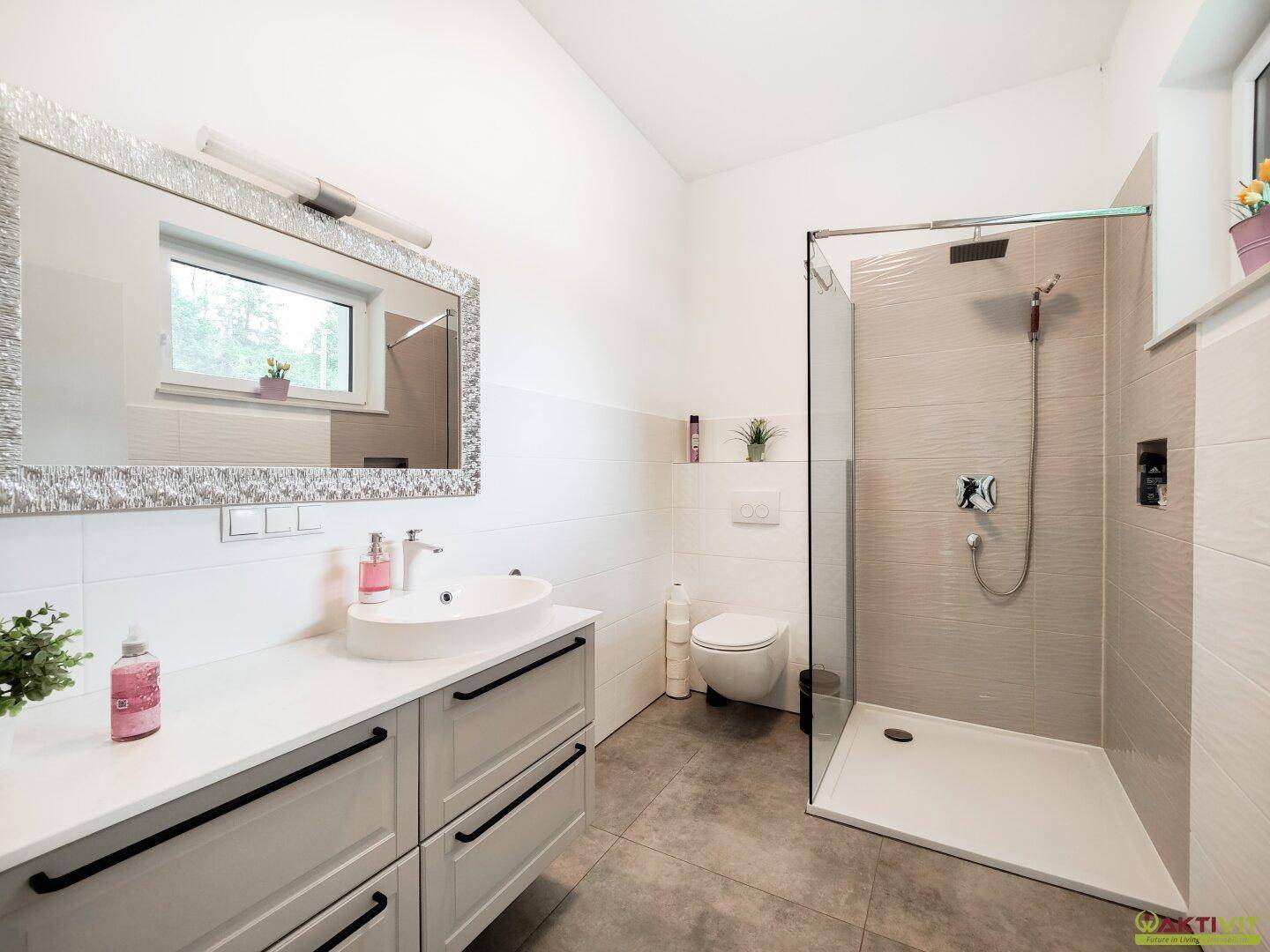 Modernes Badezimmer mit großem Waschbecken, Spiegelschrank und begehbarer Dusche.