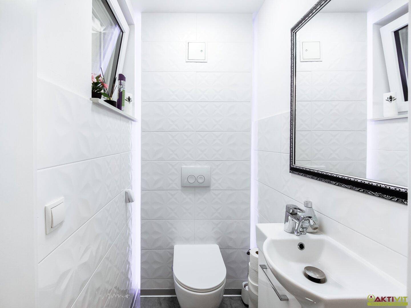 Kleines Gäste-WC mit modernem Design, Wand-WC und einem Fenster.