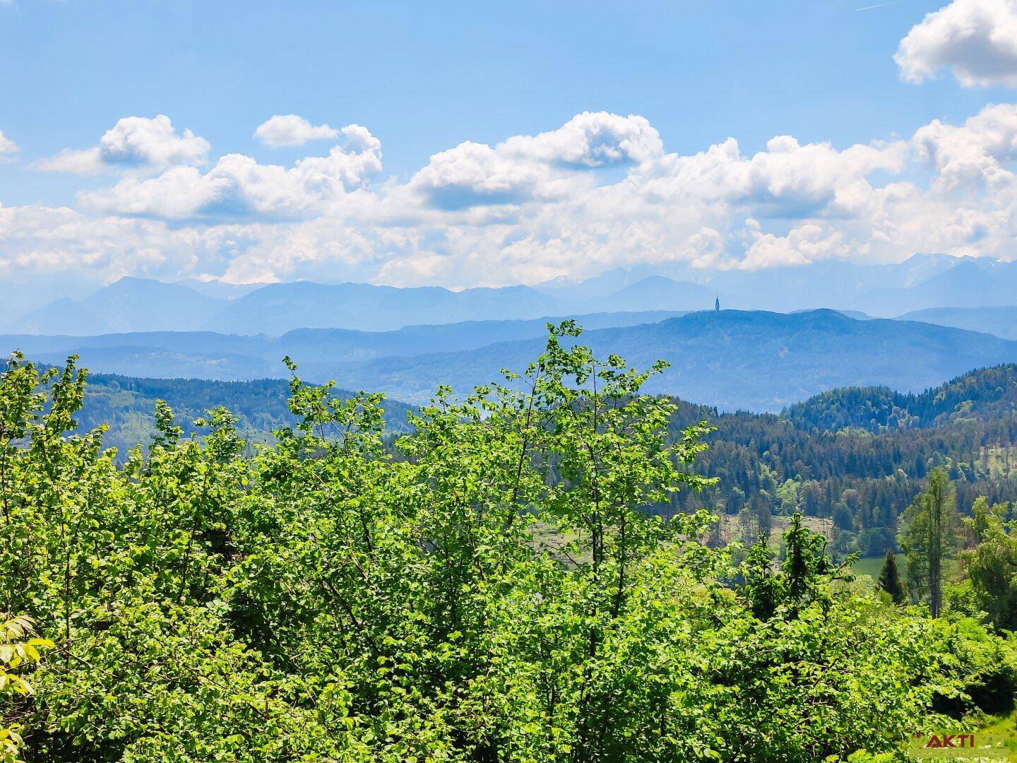 Atemberaubender Ausblick auf die weite Landschaft mit bewaldeten Hügeln und Bergketten.