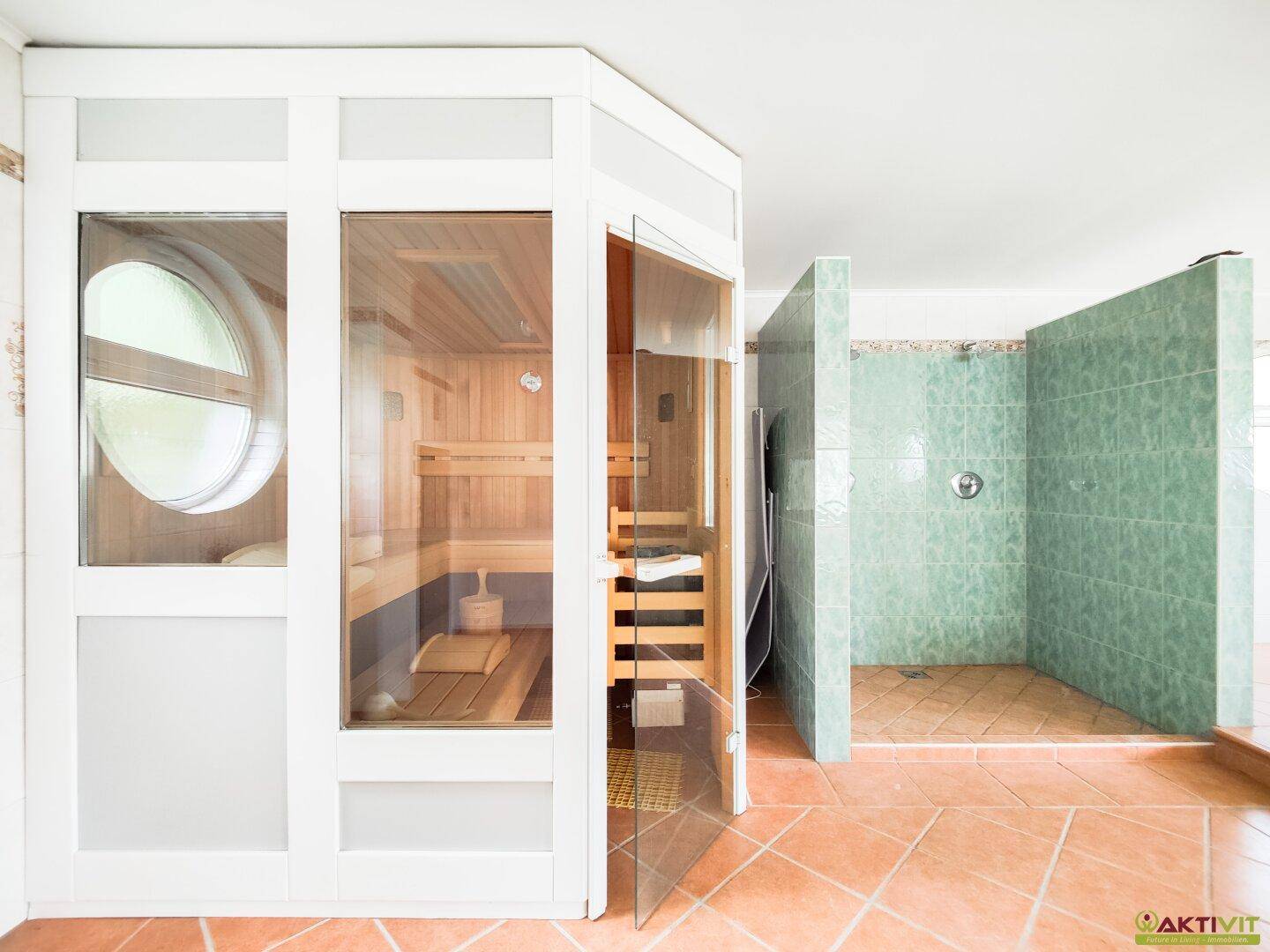 Detailansicht des Wellnessbereichs mit moderner Sauna und gefliester Duschkabine.