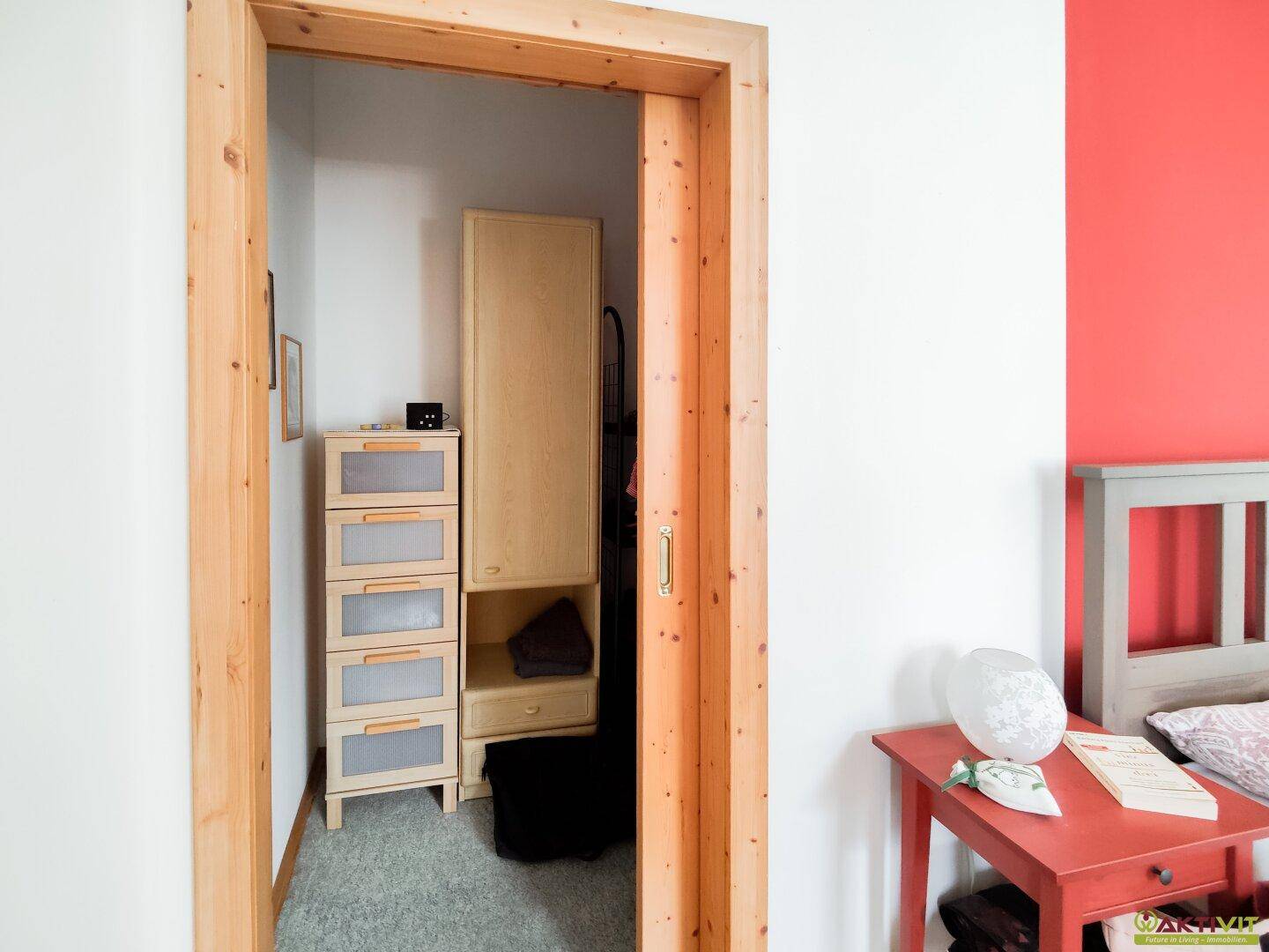Praktischer begehbarer Kleiderschrank mit Regalen und Stauraum, direkt vom Schlafzimmer zugänglich.