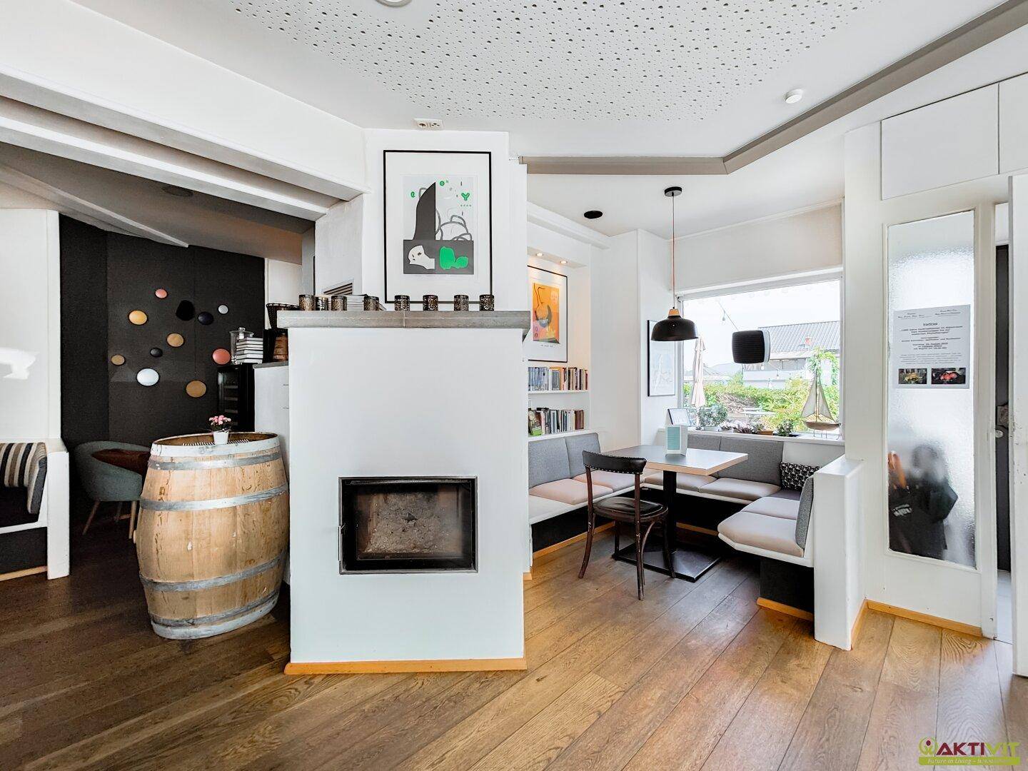 Gemütlicher Essbereich mit Holzboden und integriertem Kamin, schafft eine warme und einladende Atmosphäre.