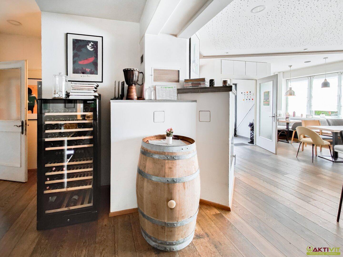 Übergangsbereich mit Holzboden und Weinkühlschrank, verbindet verschiedene Bereiche des Innenraums.