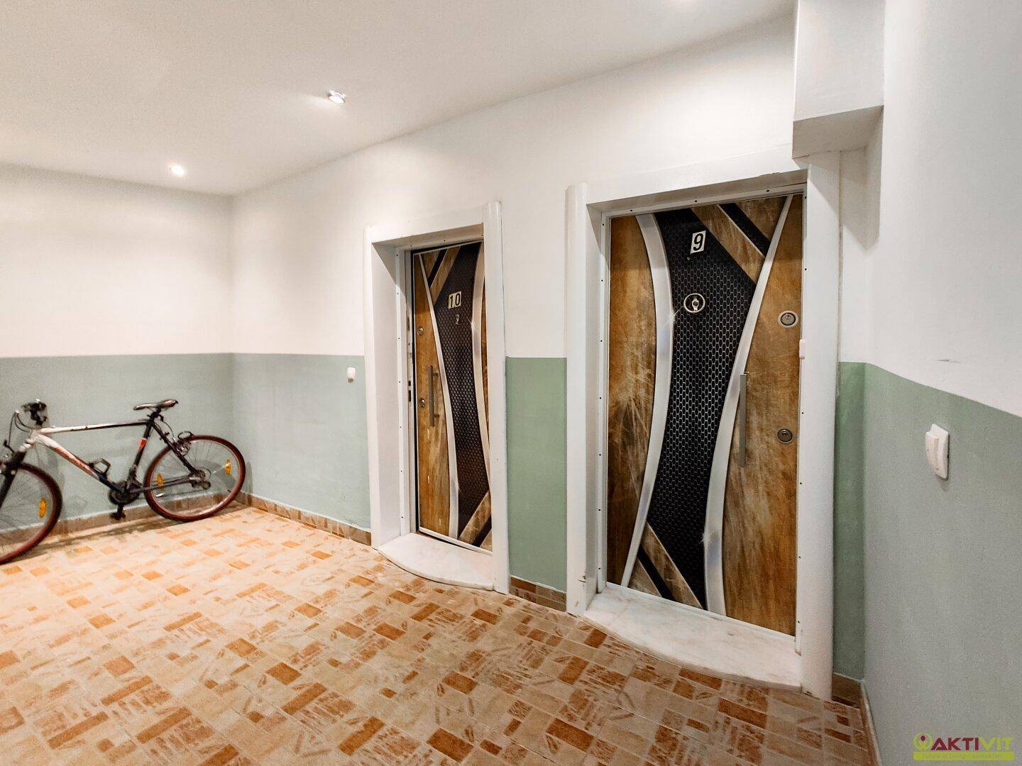 Geräumiger Flur mit zwei modernen Wohnungstüren und Abstellmöglichkeit für Fahrräder.