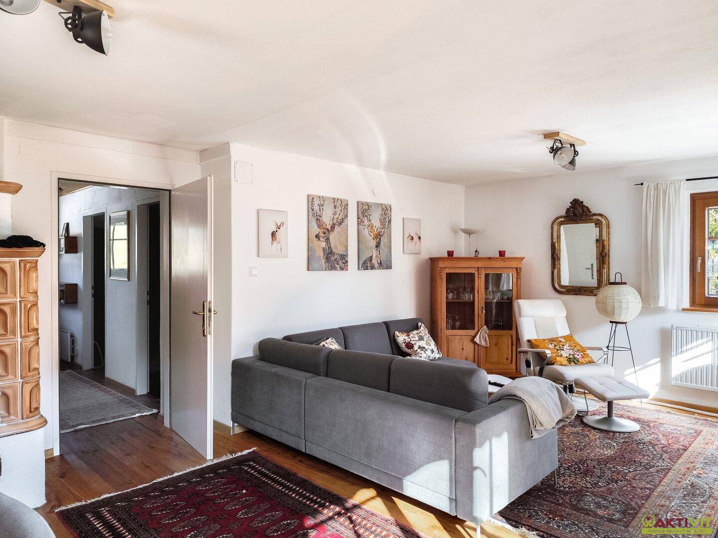 Gemütliches Wohnzimmer mit Holzboden, bequemer Couch und traditioneller Einrichtung.
