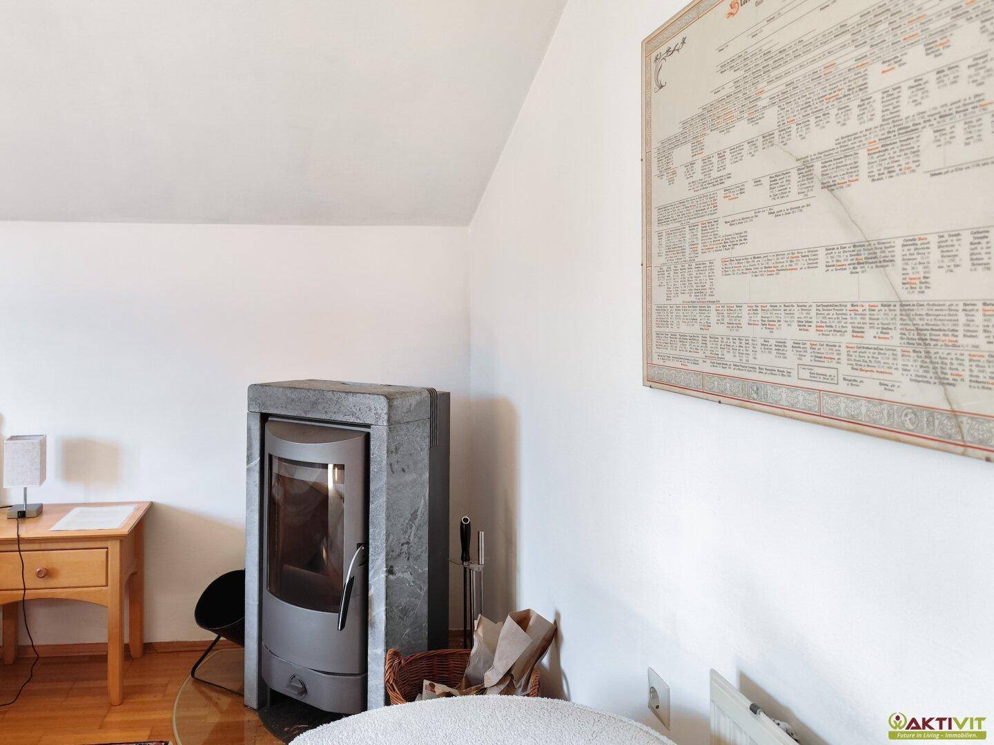 Gemütliches Schlafzimmer mit modernem Holzofen und Holzboden, ideal für kalte Tage.