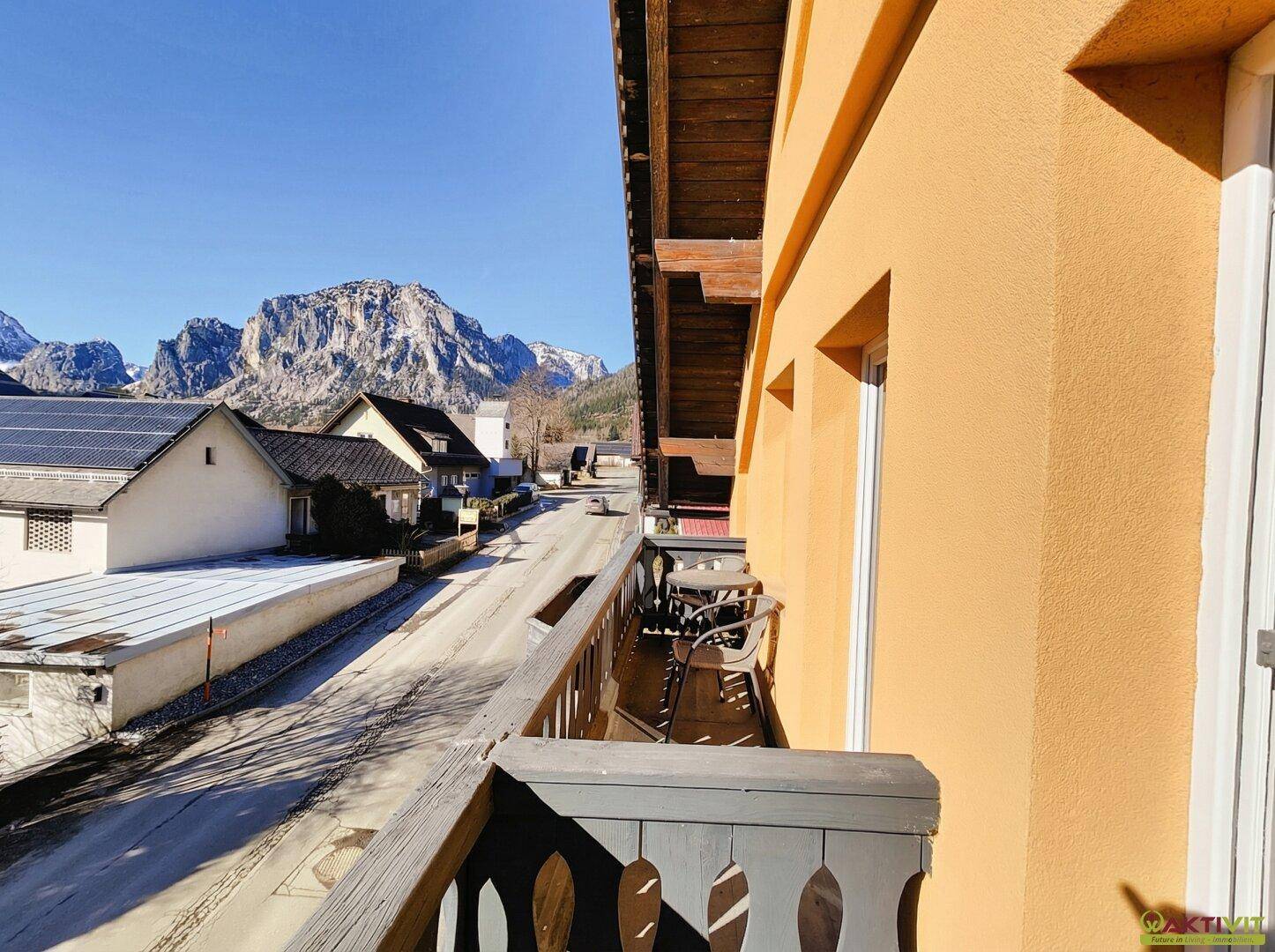 Holzbalkon mit Sitzgelegenheiten und weitem Blick auf die umliegende Berglandschaft.