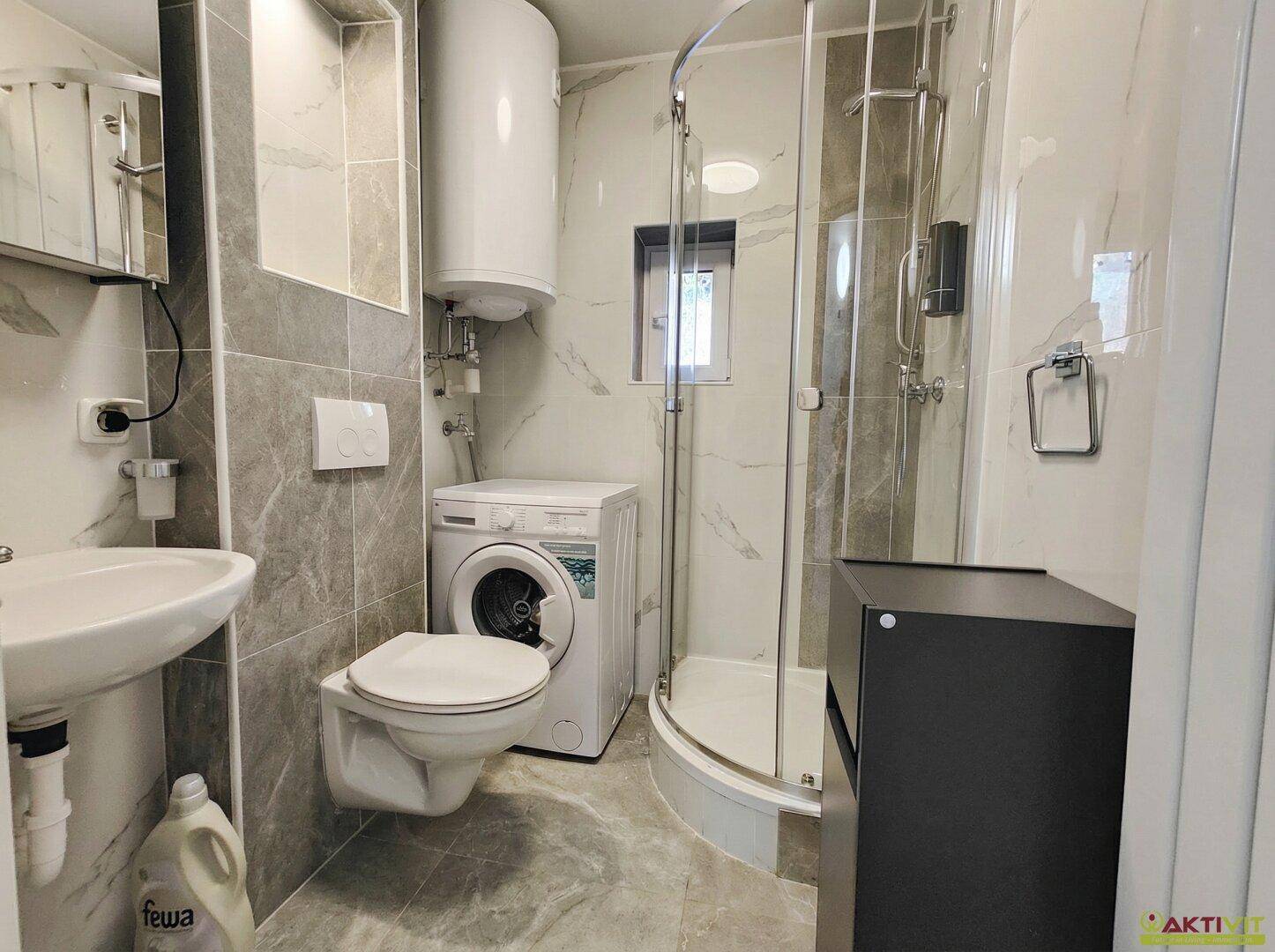 Modernes Badezimmer mit Dusche, Badewanne und beheiztem Handtuchhalter.