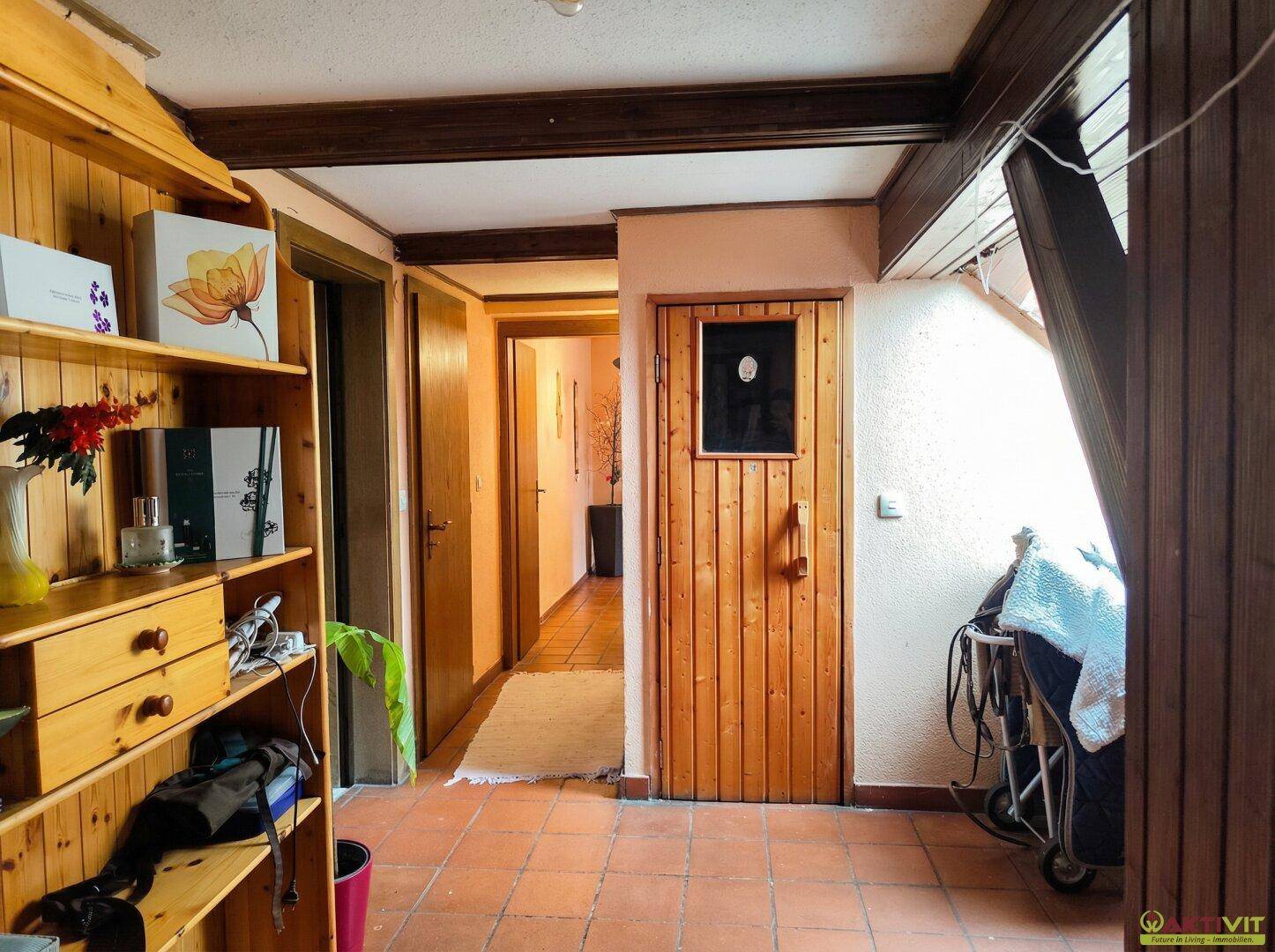 Flur mit Holzregalen und Zugang zu einer Sauna.