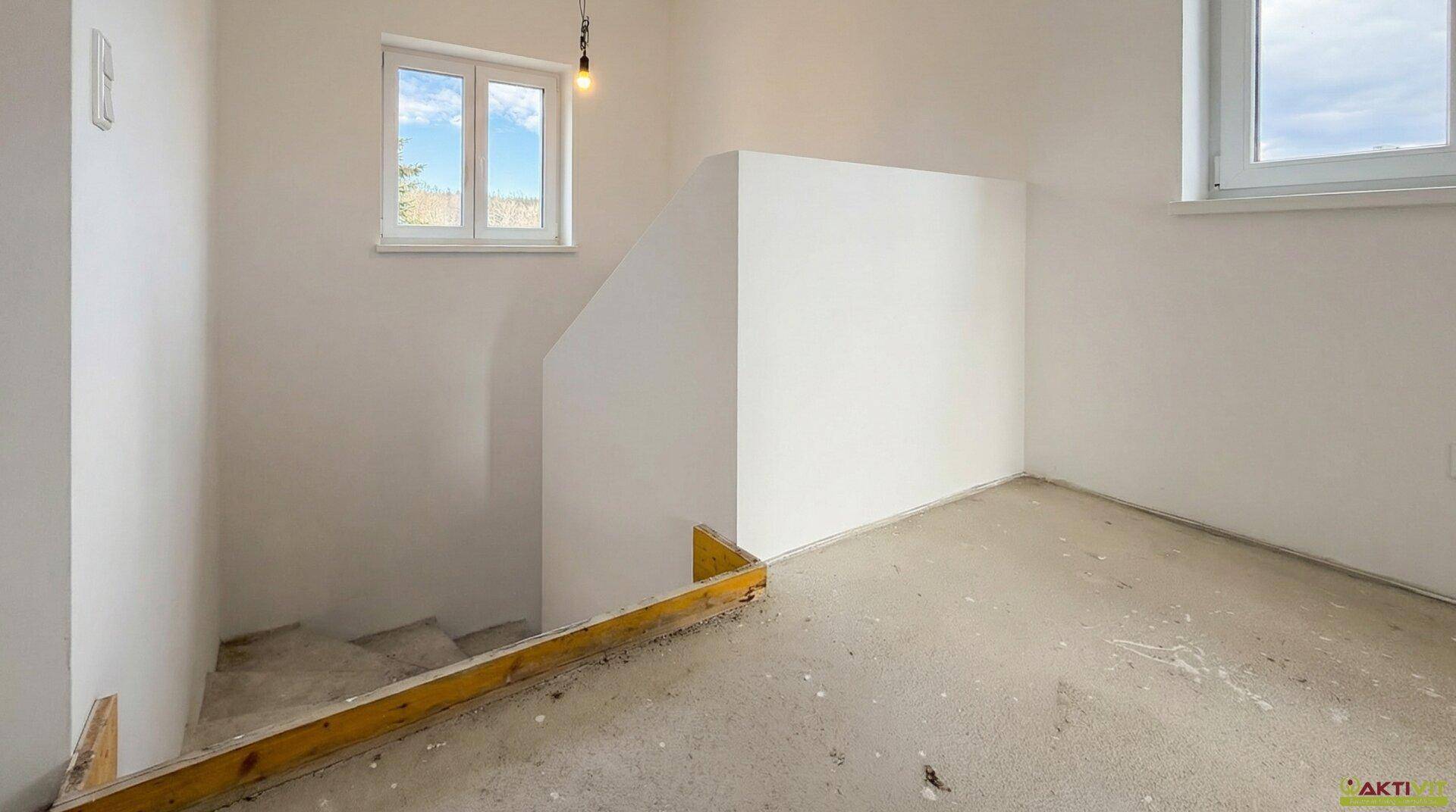 Heller Treppenabsatz im Rohbau mit Fenstern, bietet viel Tageslicht und Ausblick.