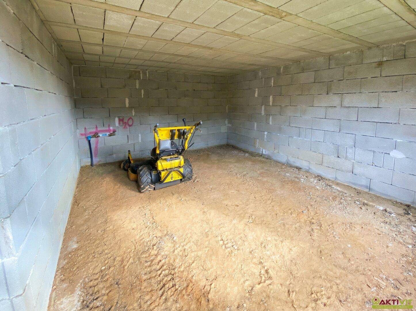 Unfertiger Raum mit Betonblockwänden und Erdboden, bereit für den weiteren Ausbau.