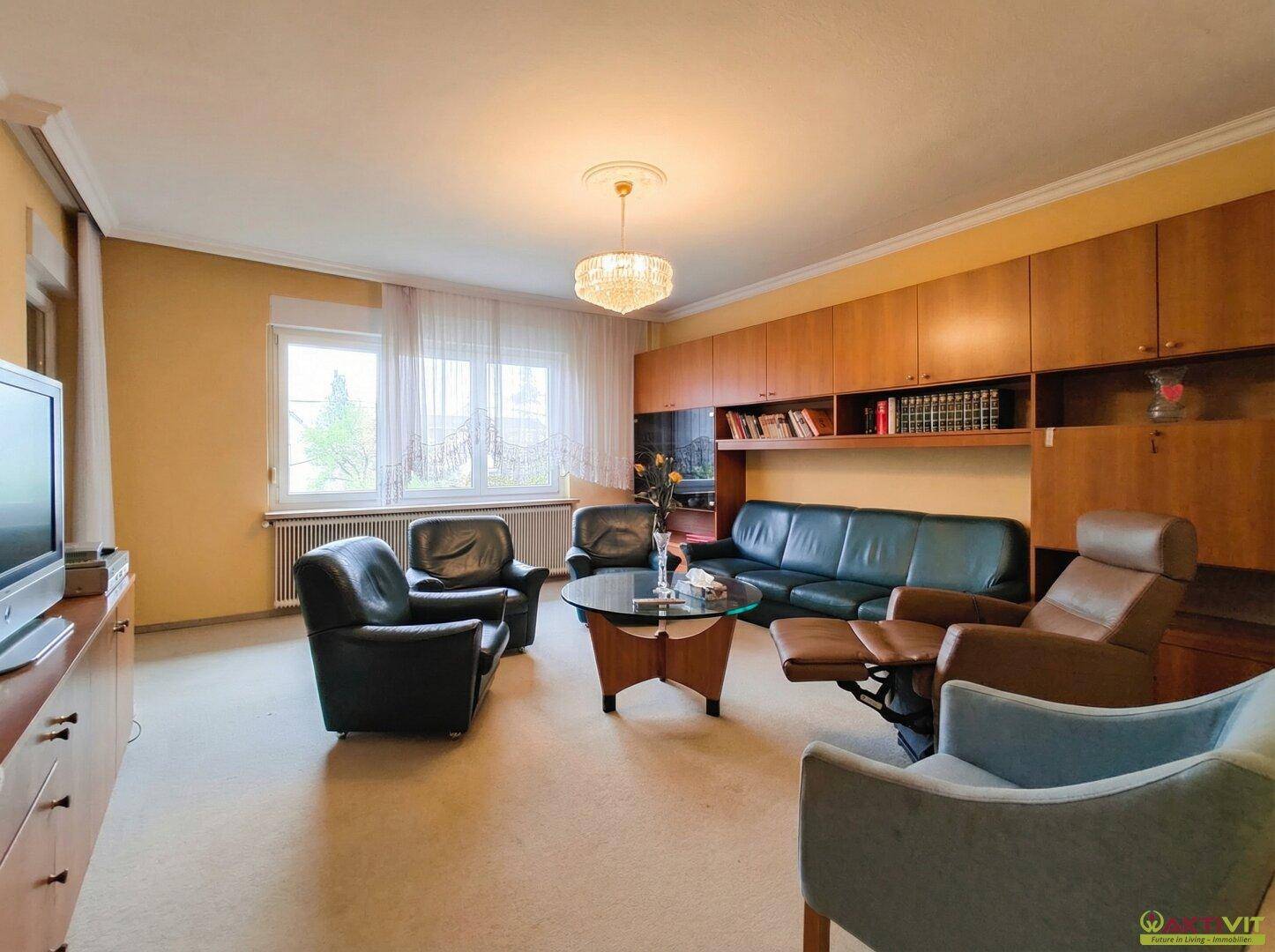 Gemütliches Wohnzimmer mit bequemen Sofas, Teppichboden und Einbauregalen.