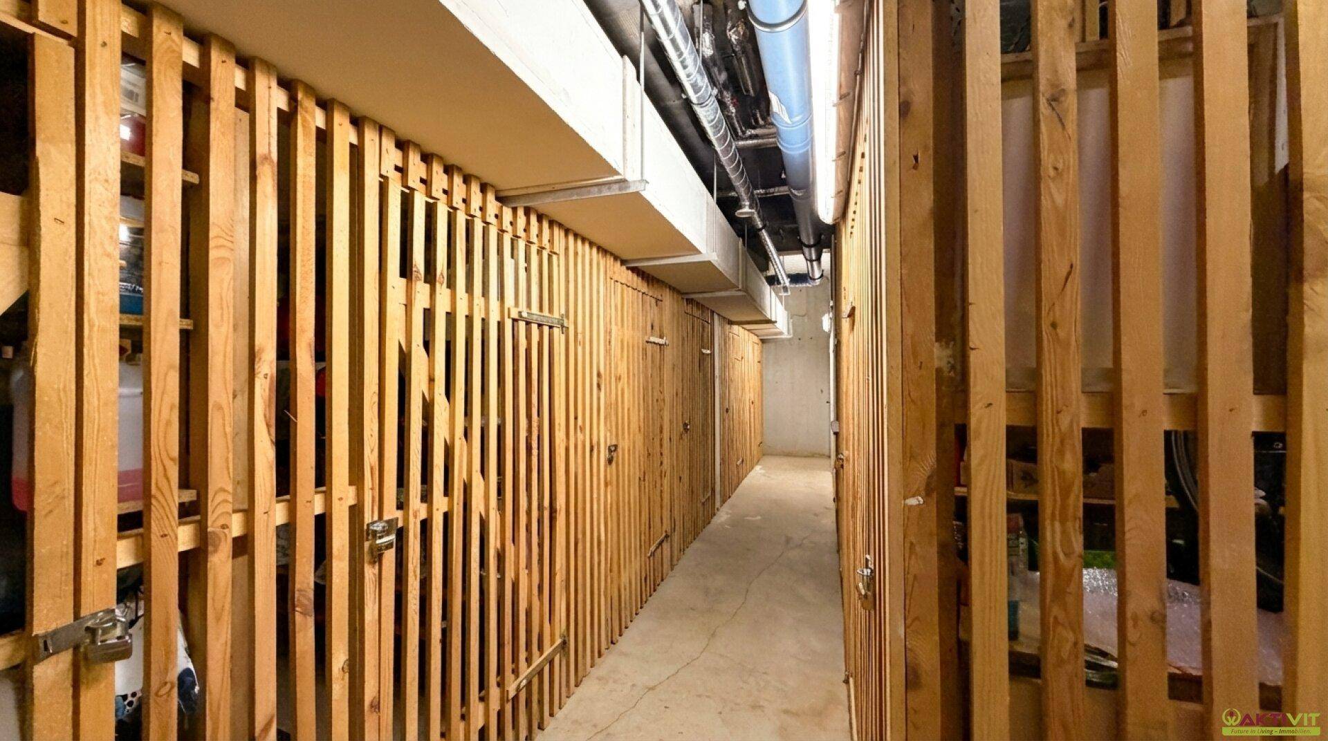 Kellerabteil mit Holzverschlägen für zusätzlichen Stauraum im Untergeschoss.