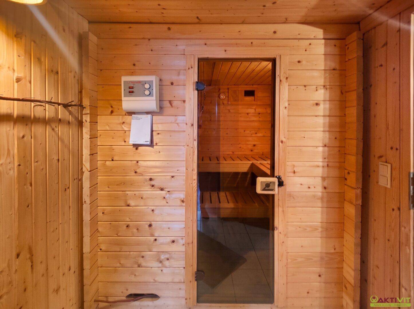 Private Sauna mit Holzbänken und Glastür, ideal zur Entspannung.