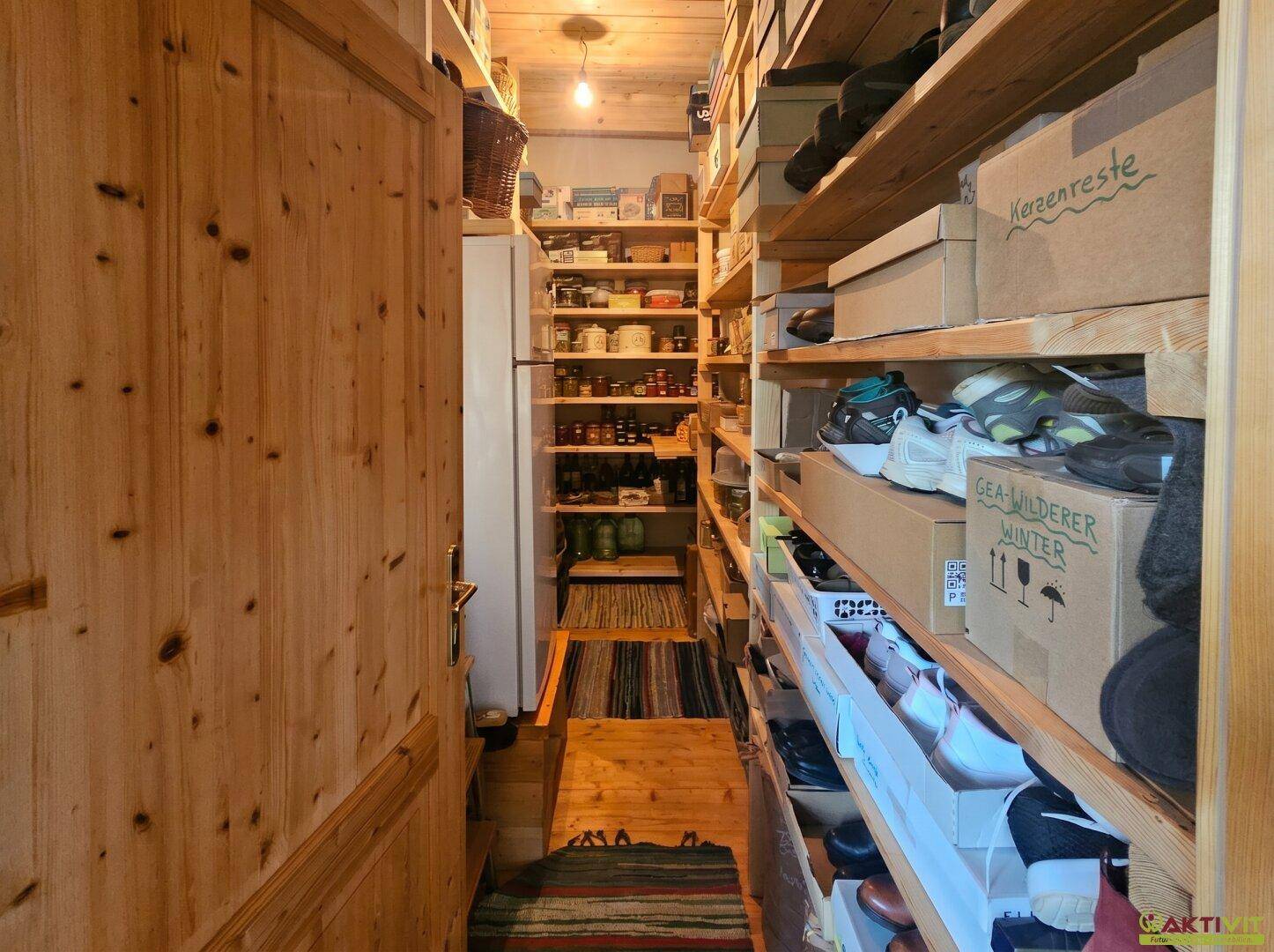 Praktische Speisekammer mit vielen Holzregalen für Vorräte und zusätzlichen Stauraum.