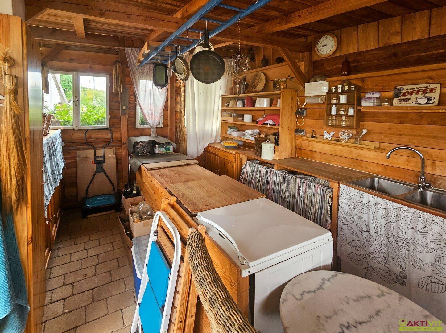 Rustikale Außenküche oder Wirtschaftsraum aus Holz mit Spüle und Stauraum.