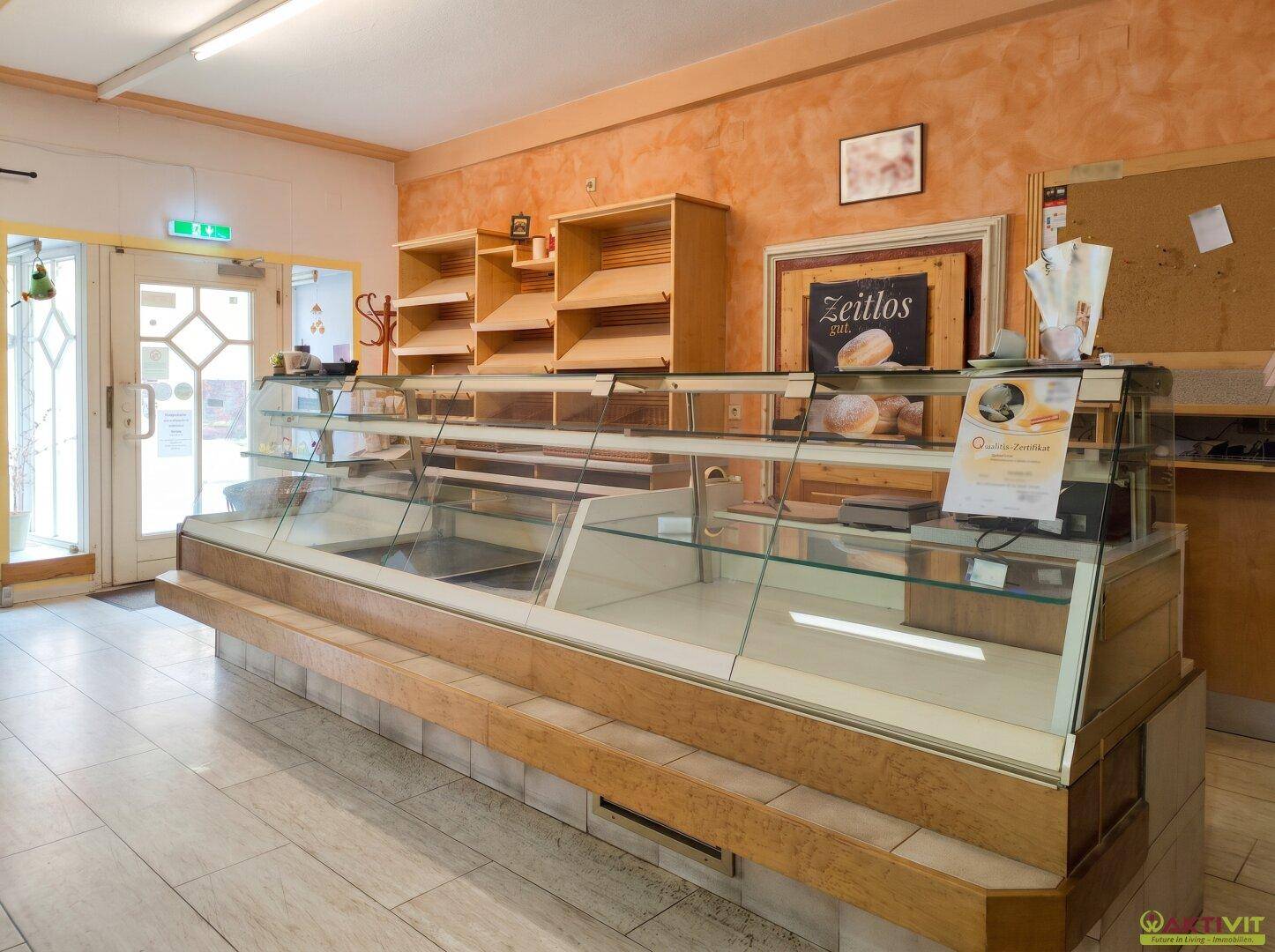 Verkaufsraum einer Bäckerei mit Theke, Auslagen und leeren Regalen.