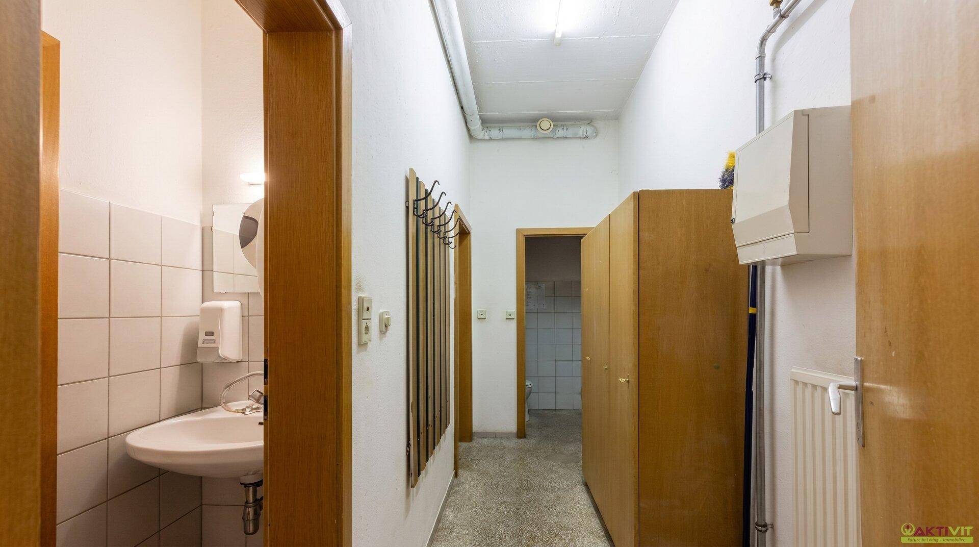 Gangbereich mit mehreren Türen, Garderobe und Zugang zu Sanitärräumen.