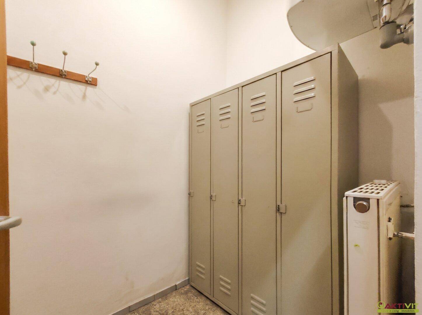 Umkleideraum mit Spinden, Garderobe und Heizkörper in einem Personalbereich.