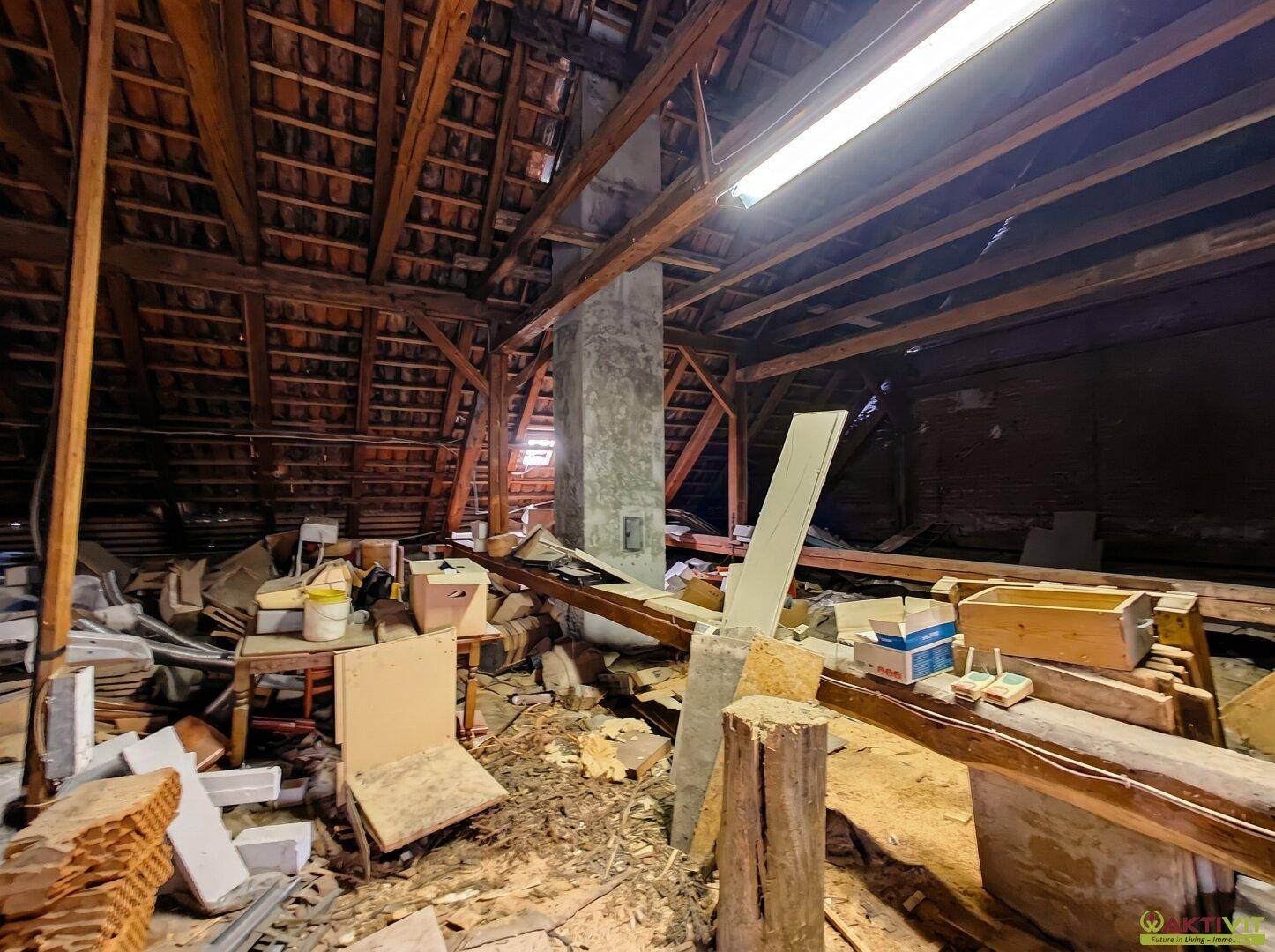 Unausgebauter Dachboden mit sichtbaren Holzbalken und Lagerfläche.