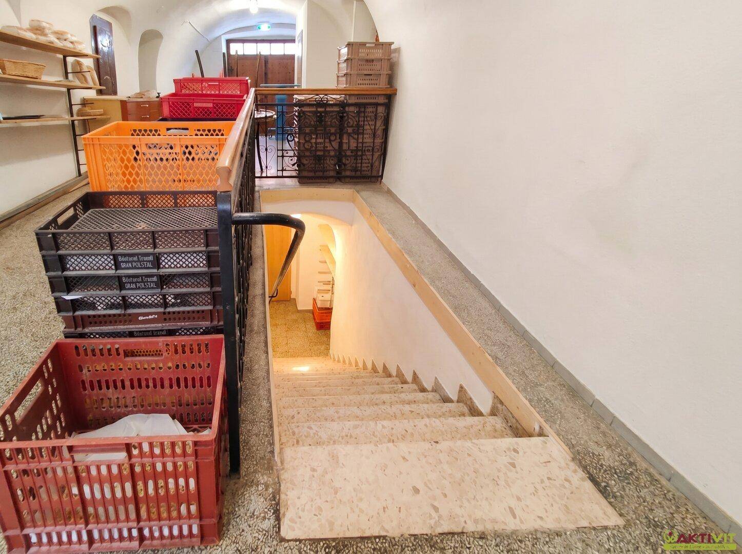 Treppe und Rampe führen in einen Kellerbereich mit Lagerkisten.