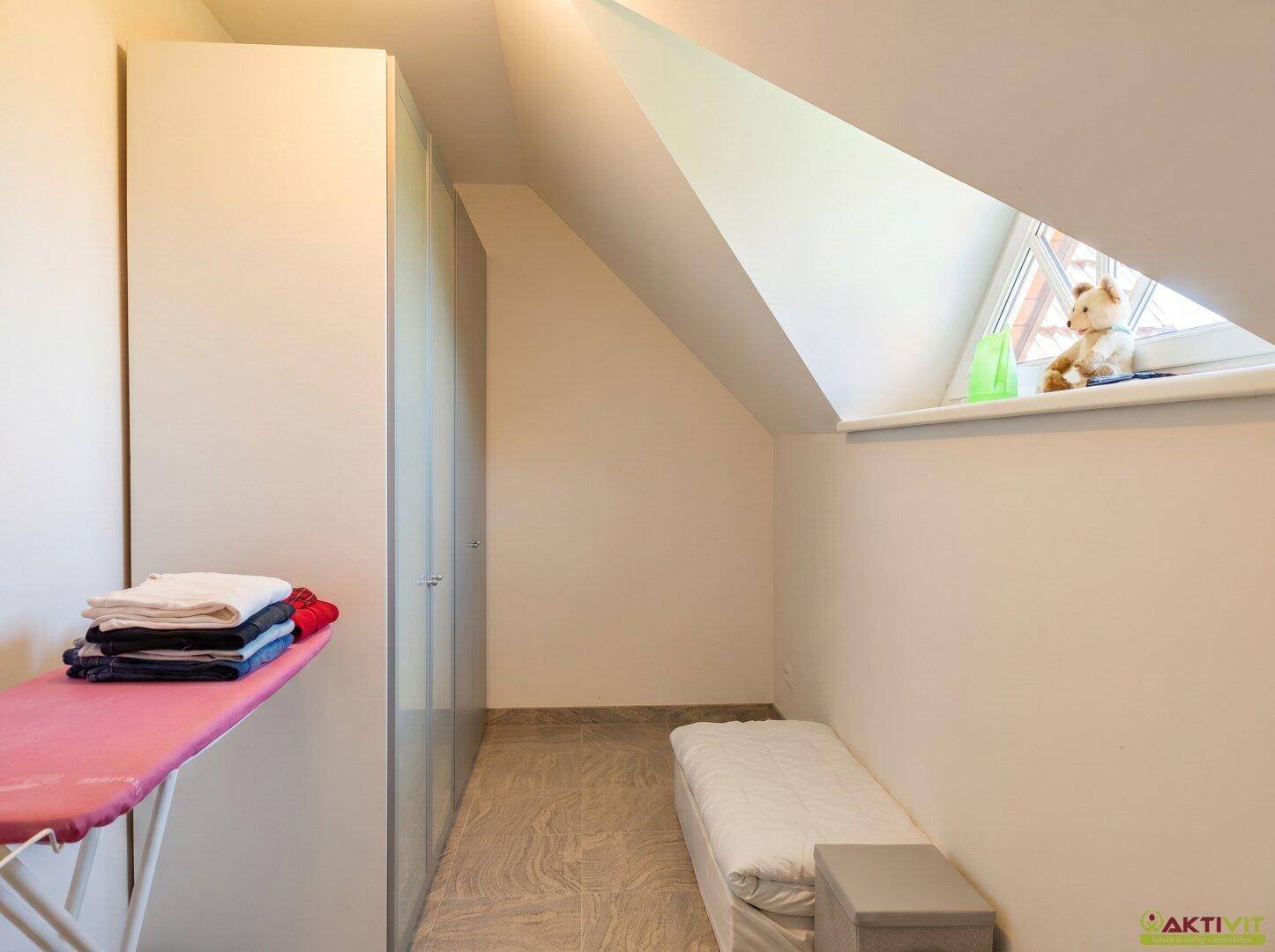 Kleiner Raum im Dachgeschoss mit Stauraum und Dachfenster, ideal als Abstellraum.