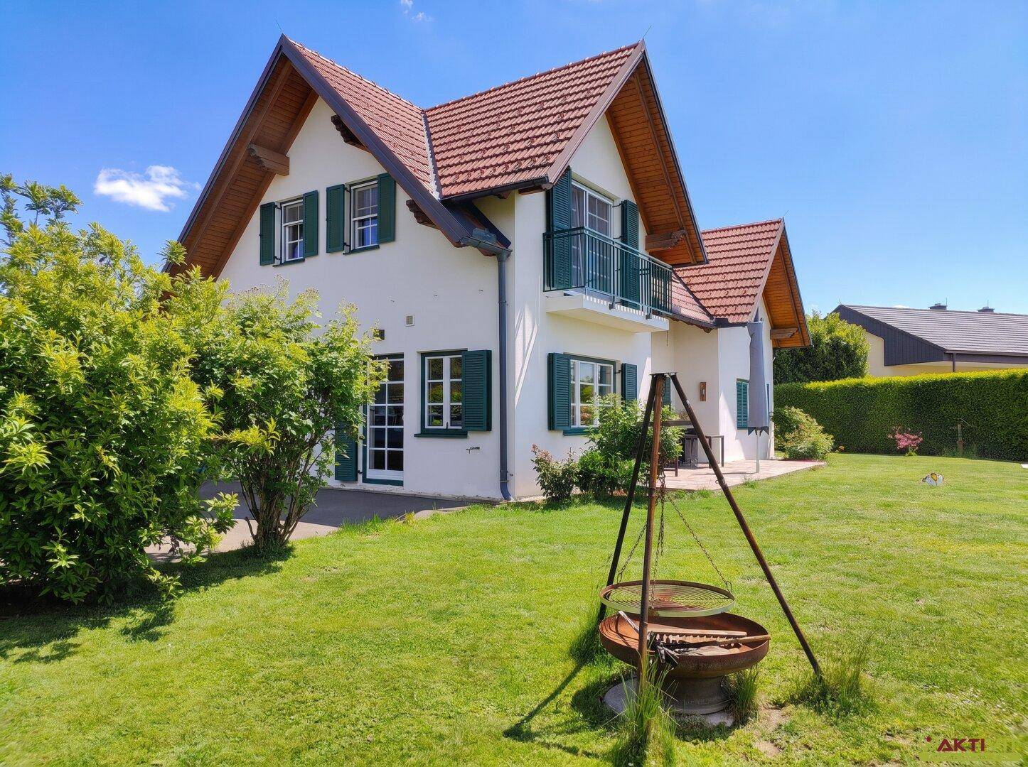 Gepflegter Gartenbereich mit Rasenfläche und einer Feuerstelle neben dem Haus.
