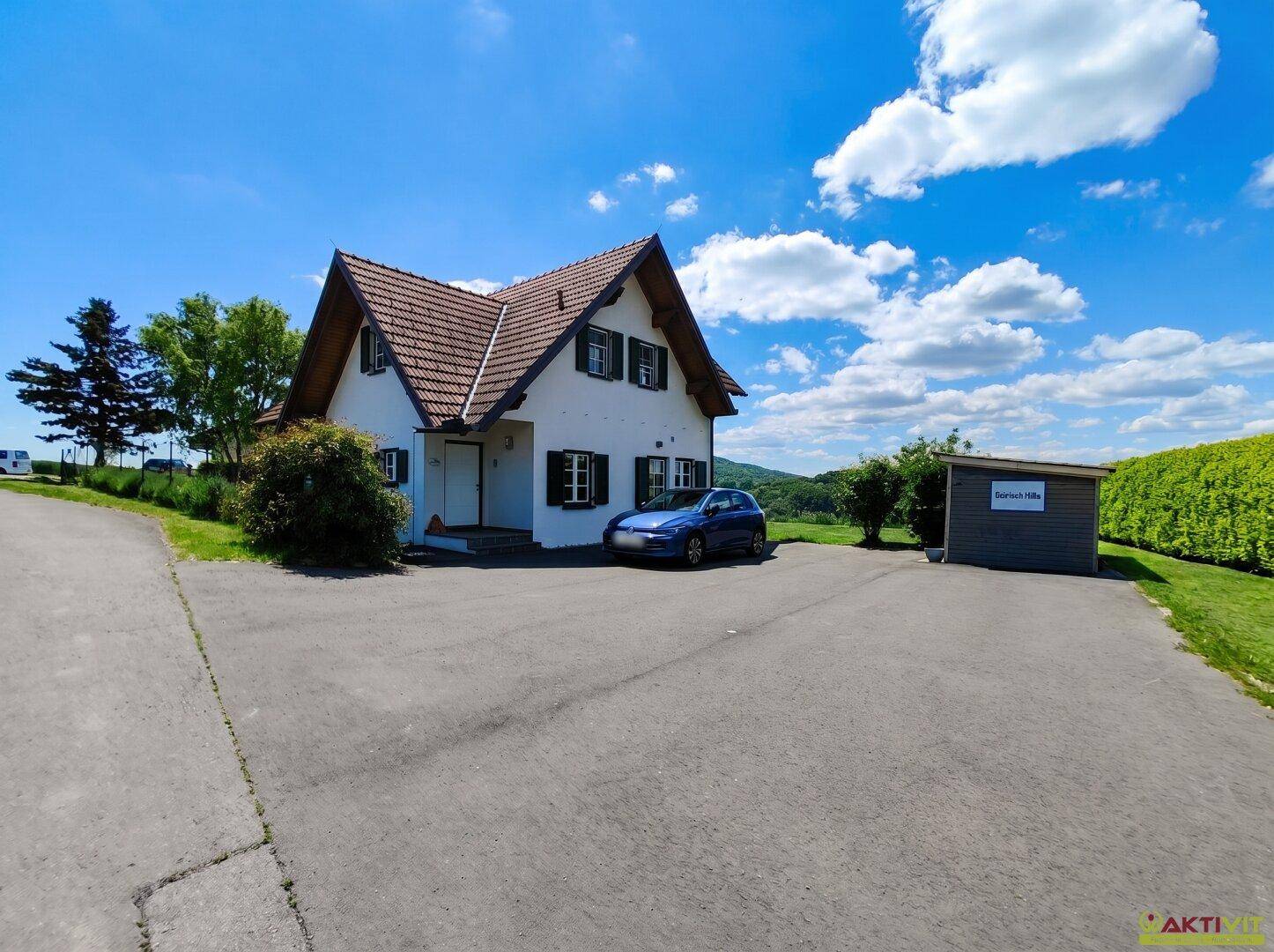 Vorderansicht des Hauses mit großer Auffahrt und einem praktischen Gartenschuppen.