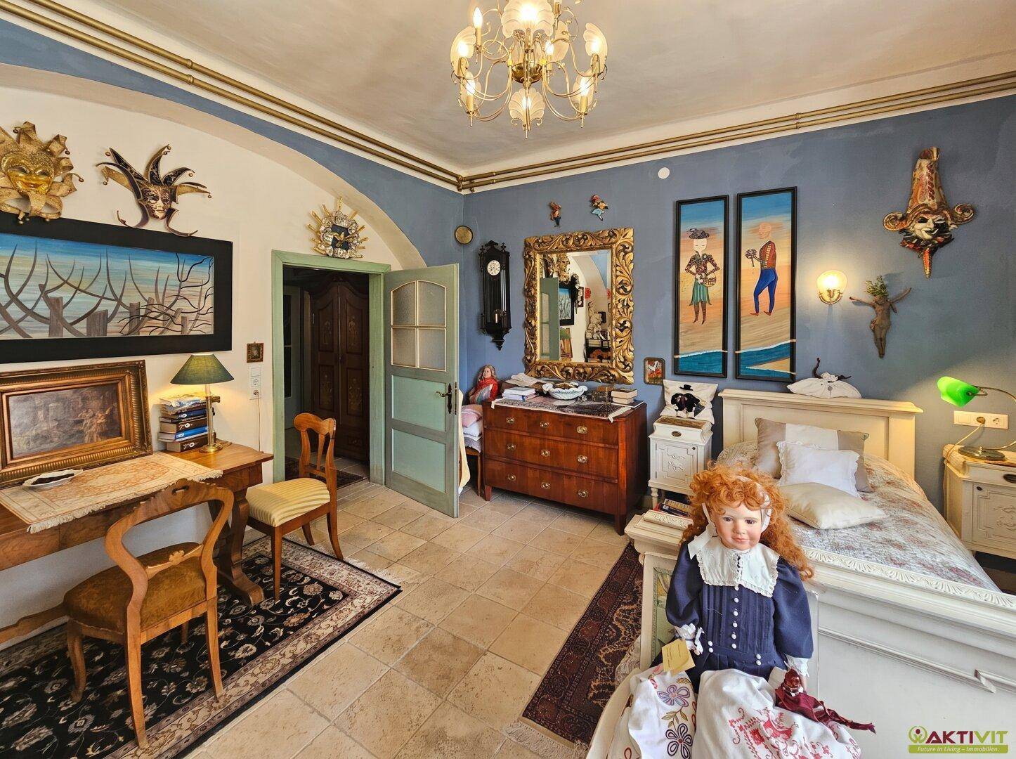 Gemütliches Schlafzimmer mit blauen Wänden, Fliesenboden und antiken Möbeln.