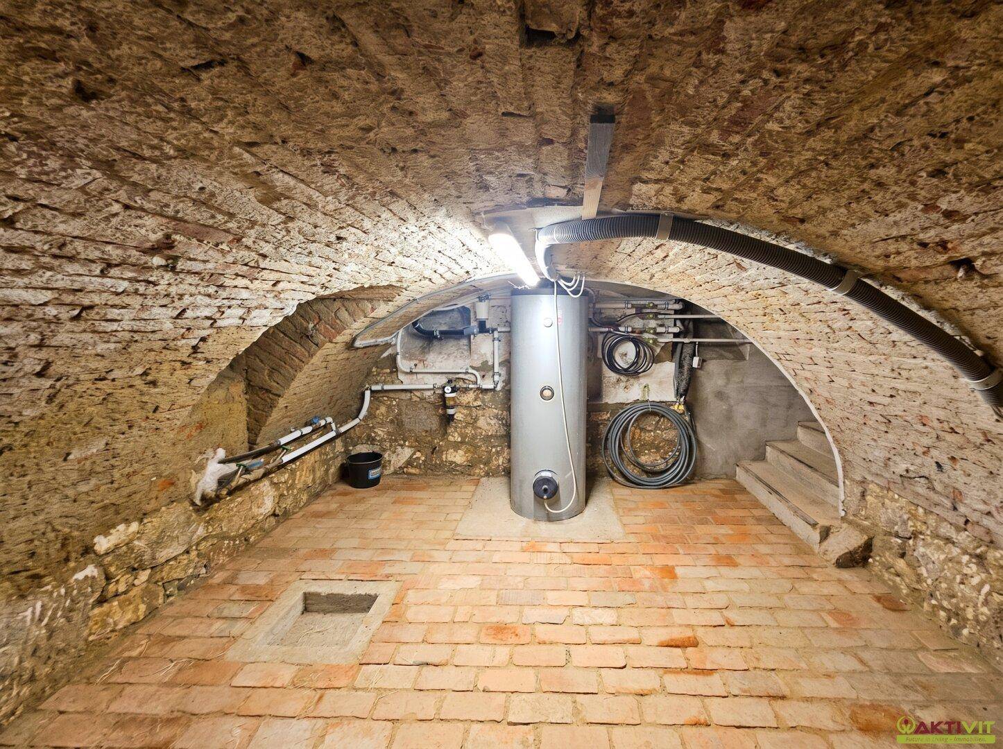 Historischer Gewölbekeller mit Ziegelwänden und Heizungsanlage.
