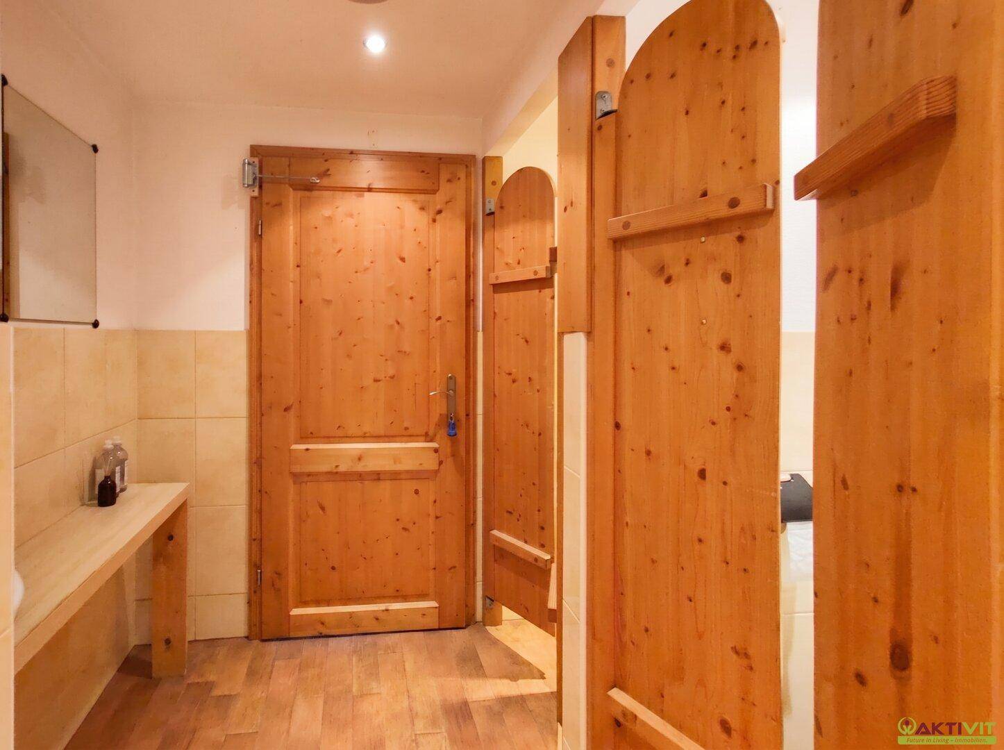 Umkleidebereich mit Holztüren und einer Holzbank, möglicherweise Zugang zu einem Wellnessbereich.