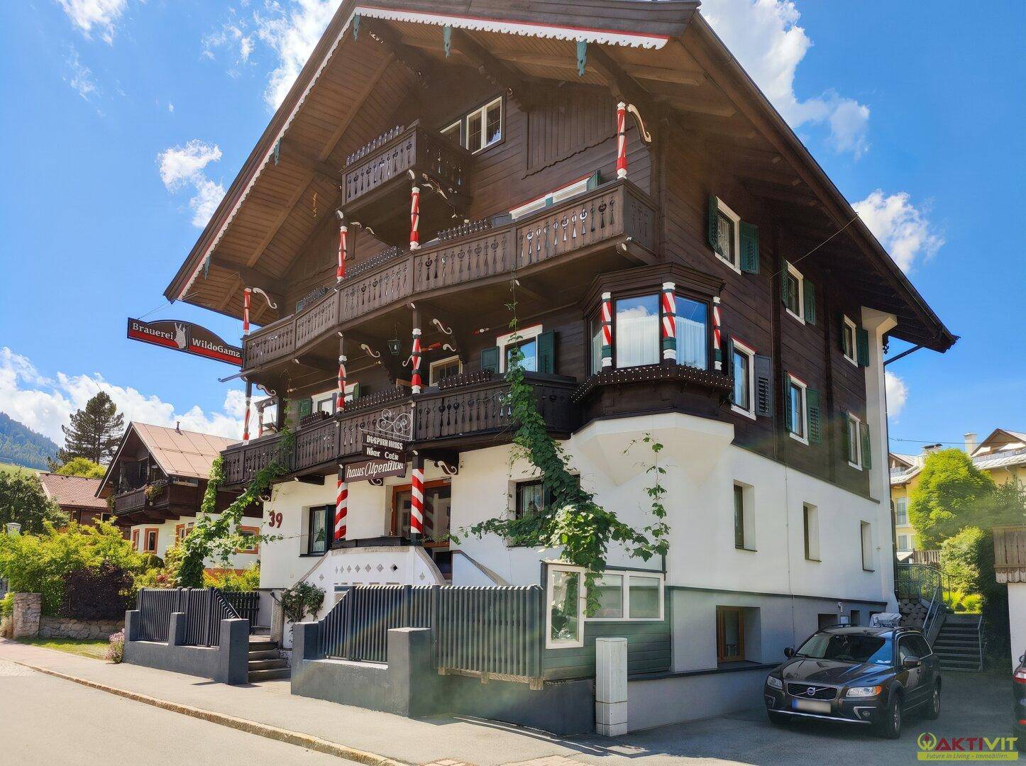 Großes traditionelles Gebäude im Alpenstil mit Holzbalkonen und einer gepflegten Fassade.