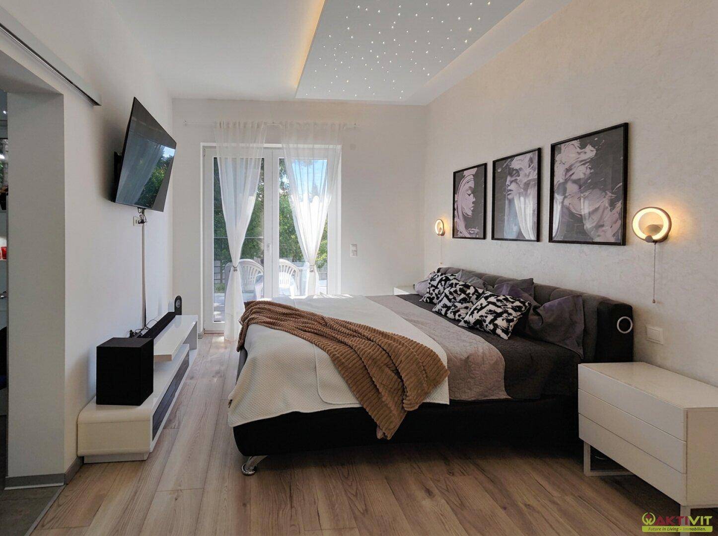 Gemütliches Schlafzimmer mit Holzboden, Sternenhimmel-Decke und Terrassenzugang.