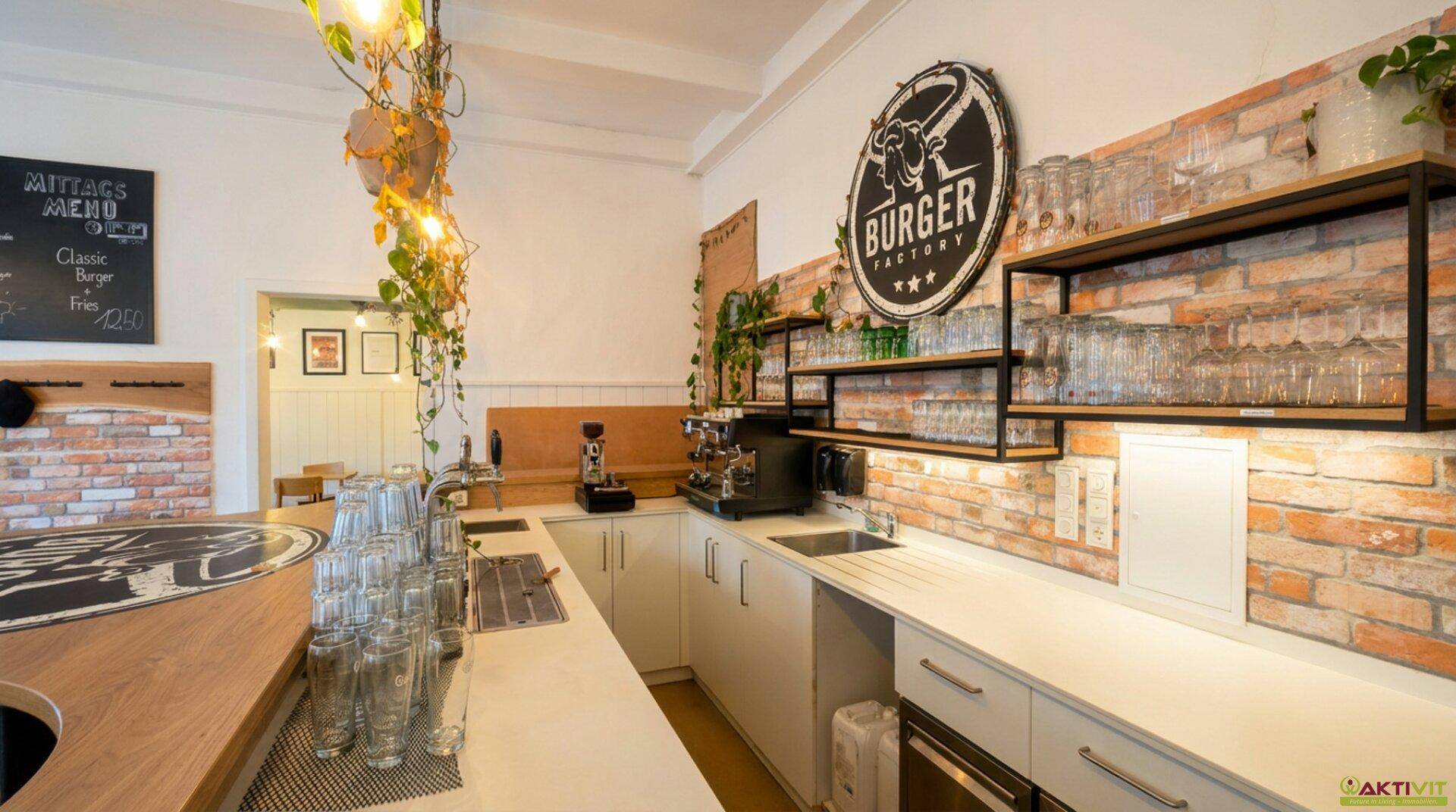 Professioneller Barbereich mit Spülbecken, Kaffeemaschine und Regalen, akzentuiert durch eine Backsteinwand.