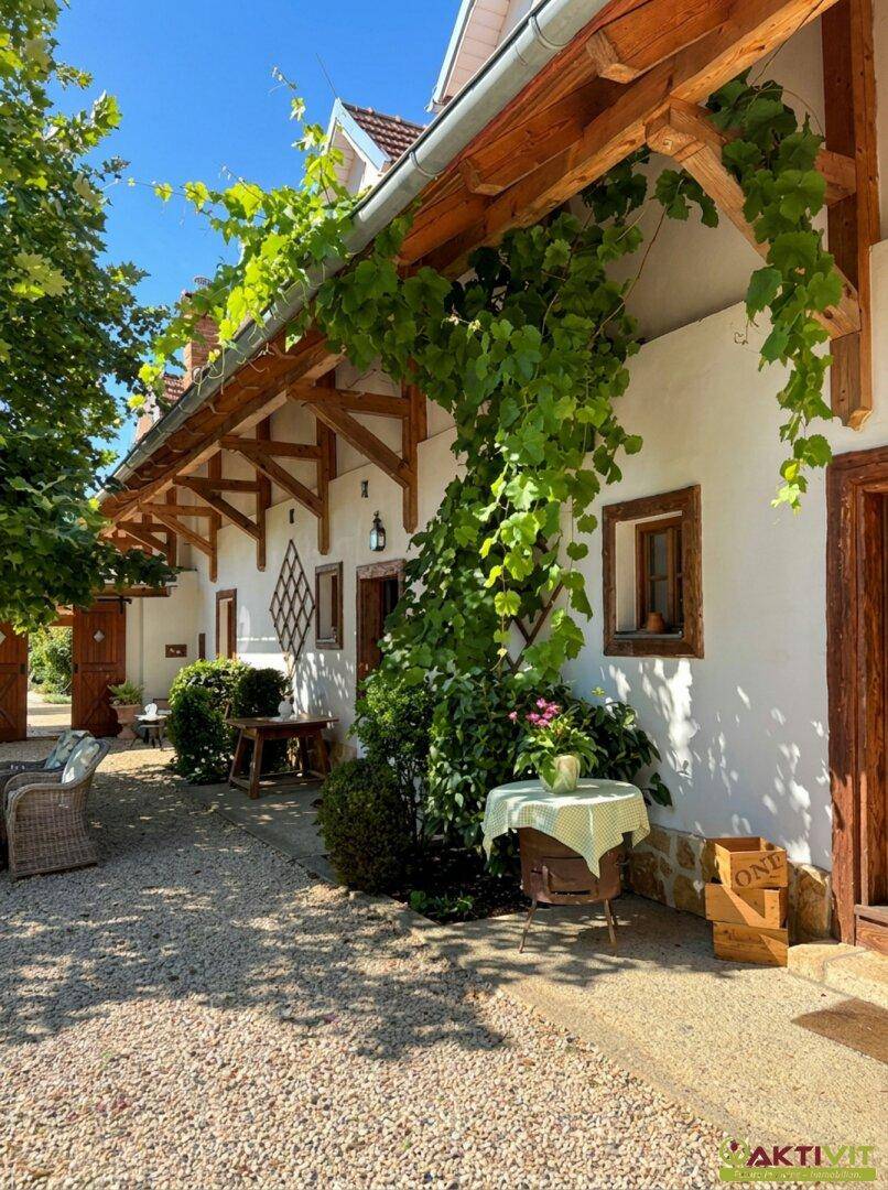 Malerischer Weg entlang des Hauses mit üppigem Grün und Holzbalken.