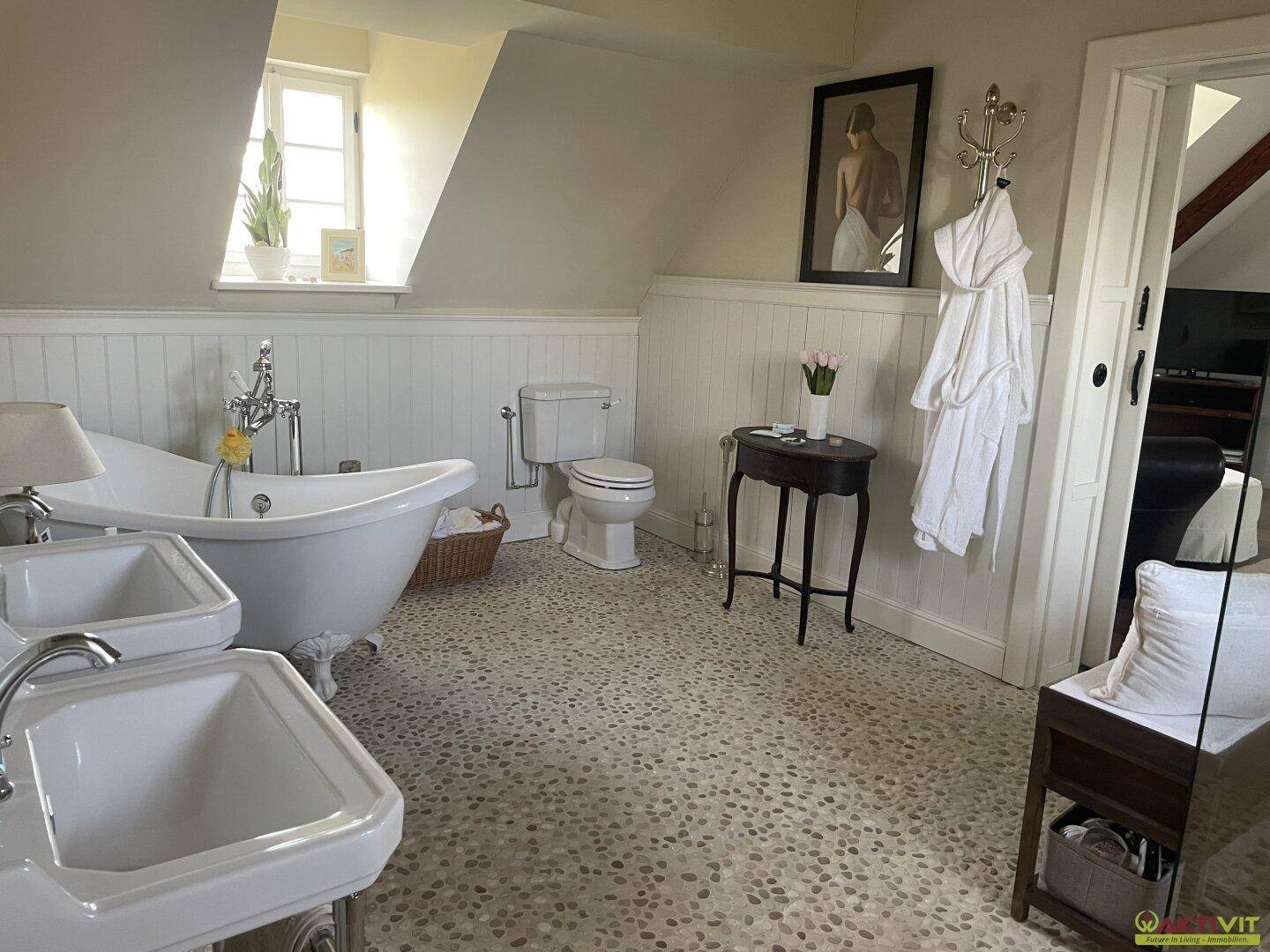 Geräumiges Badezimmer im Dachgeschoss mit freistehender Badewanne und Doppelwaschbecken.