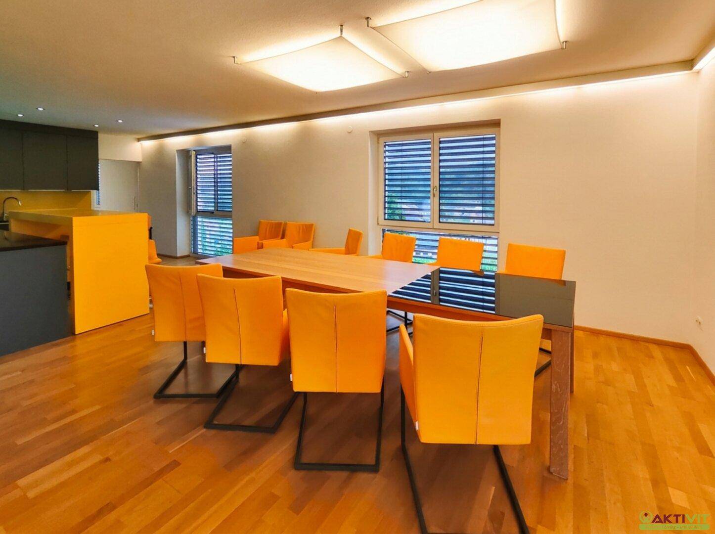 Offener Wohn- und Essbereich mit Holzboden, modernen Möbeln und viel natürlichem Licht.