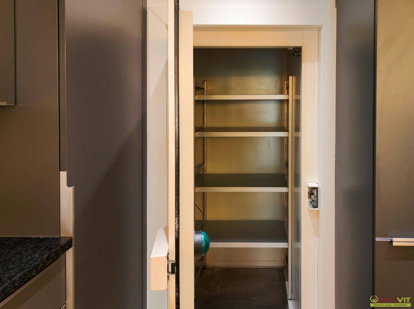 Praktische Speisekammer mit Regalen für Vorräte, direkt angrenzend an die Küche.