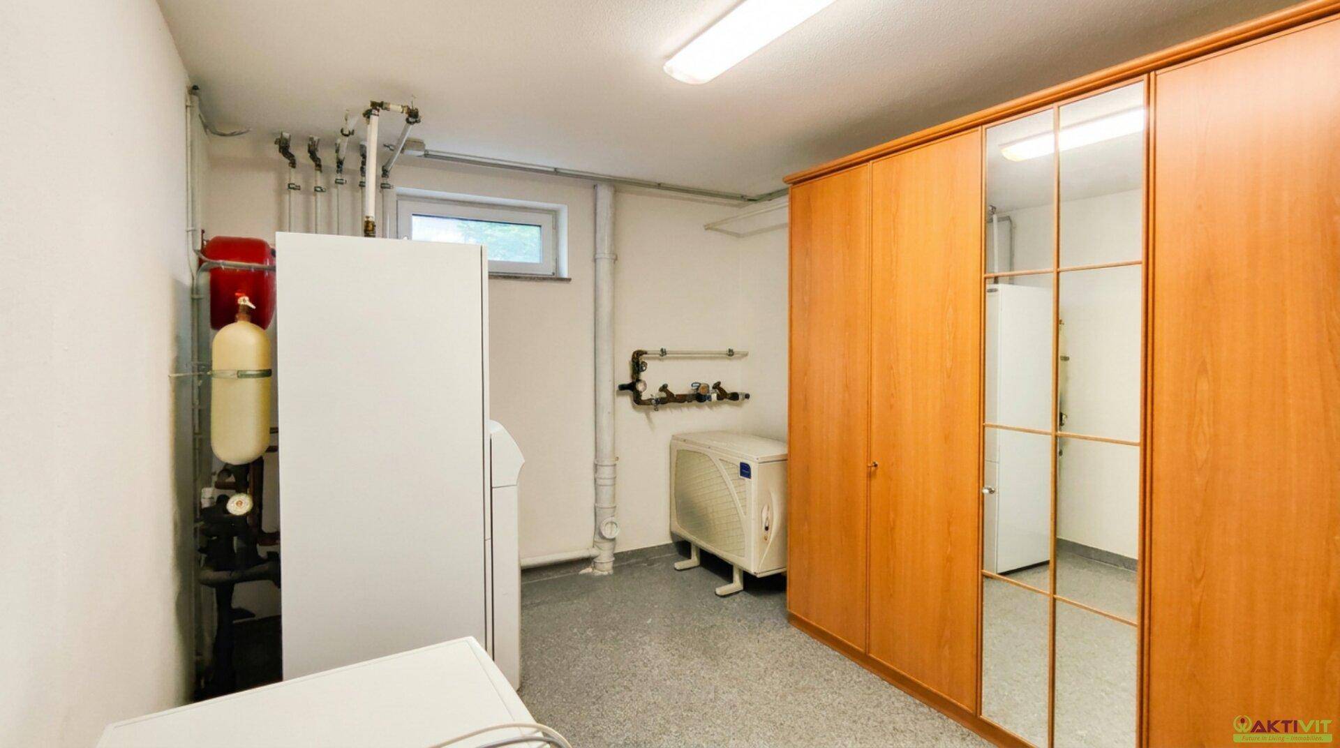 Heizungsraum mit moderner Technik, Warmwasserspeicher und praktischen Spiegelschränken.
