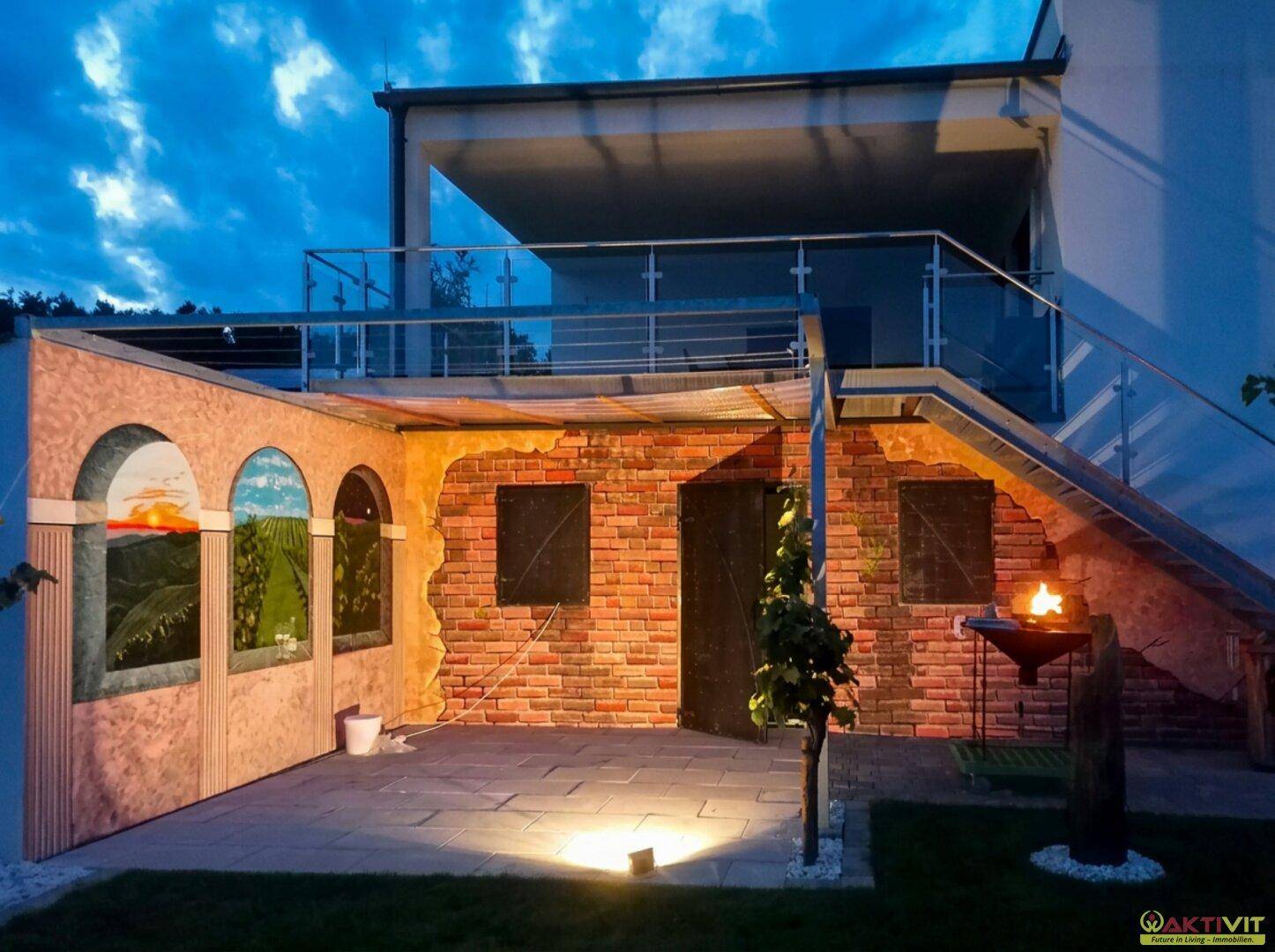 Mediterraner Außenbereich mit gemalter Wand, Grillplatz und modernem Balkon im oberen Bereich.