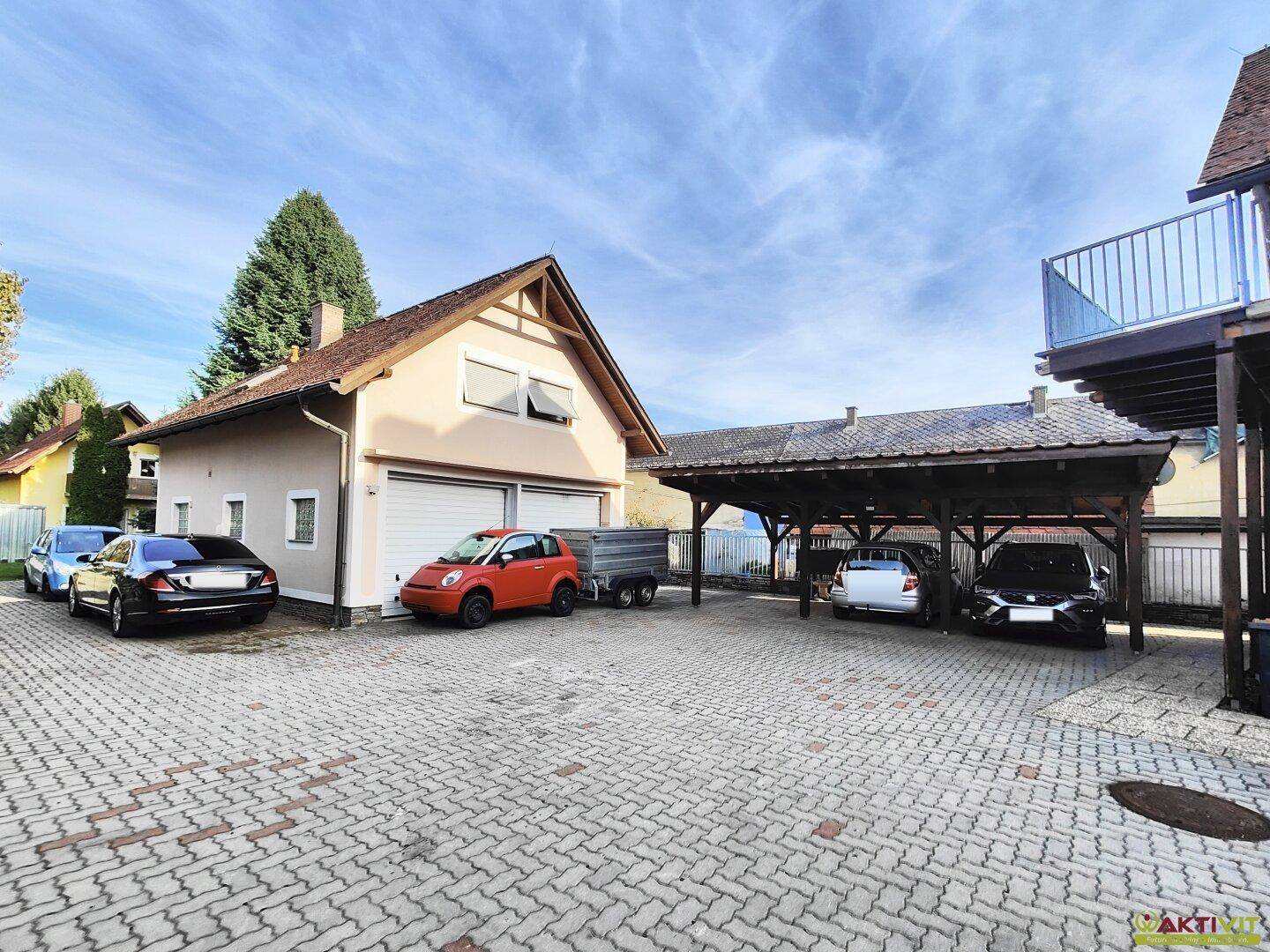 Geräumiger Hofbereich mit Garage, Carport und ausreichend Stellplätzen für mehrere Fahrzeuge.