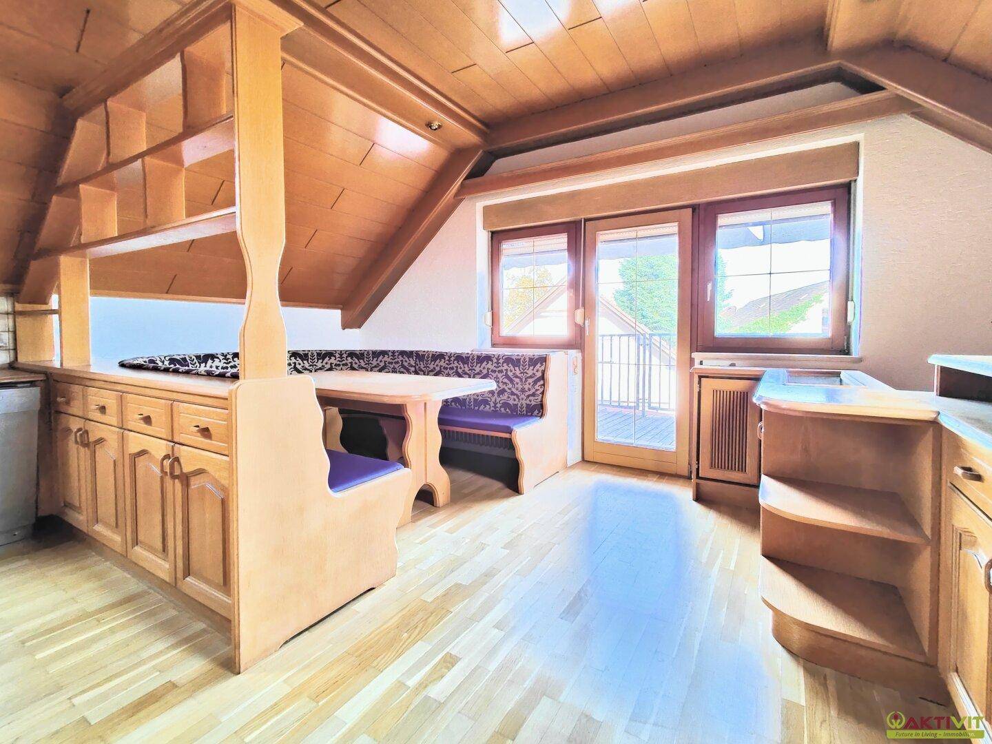 Essbereich im Dachgeschoss mit Holzboden, Einbauschränken und traditionellem Design.