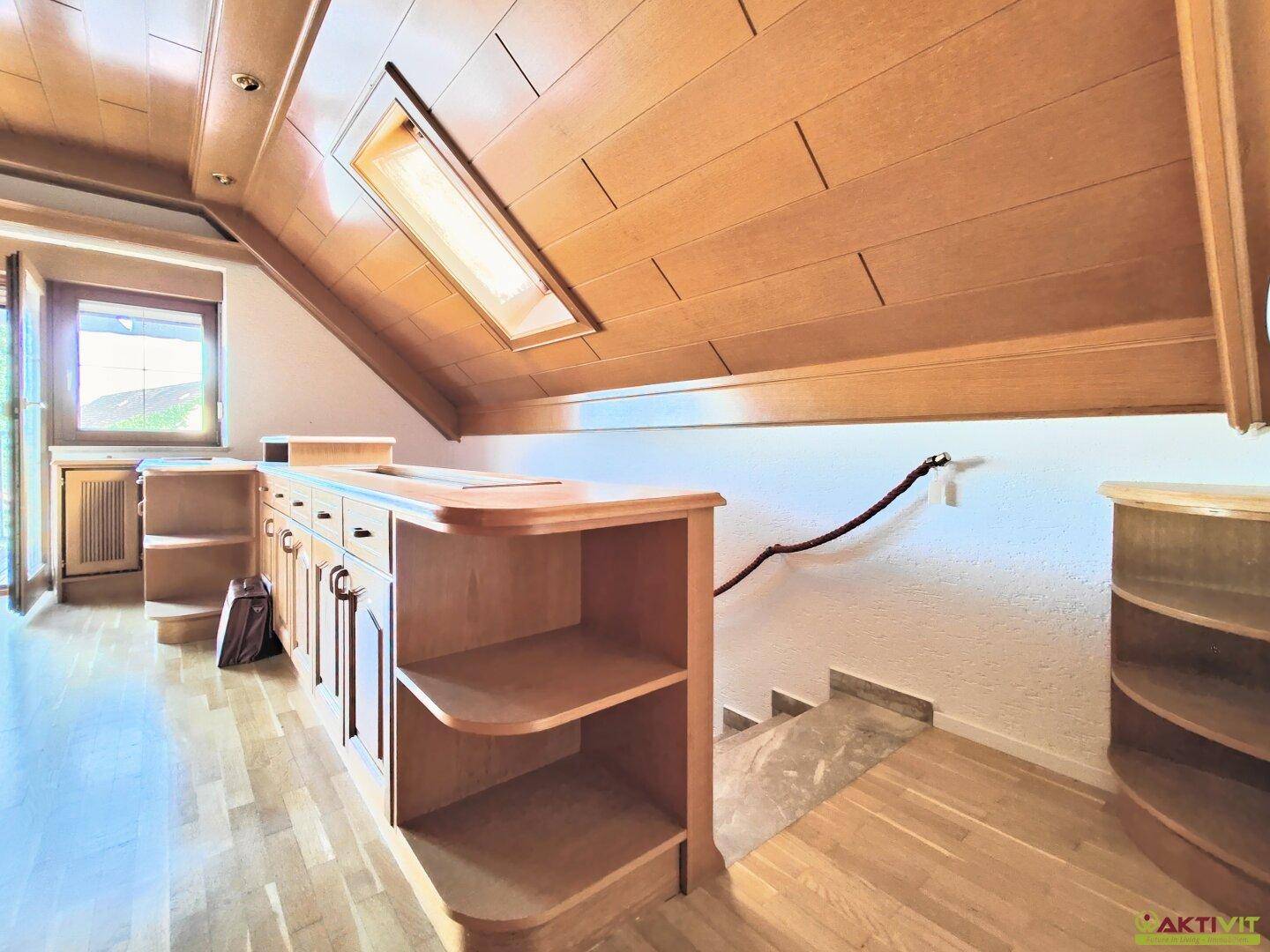 Flur im Dachgeschoss mit Holzdecke, Einbauschränken und Treppenaufgang, hell und geräumig.