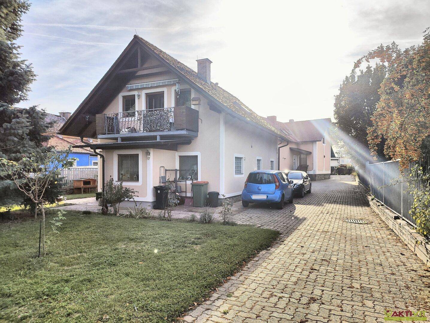 Das Haus mit seiner langen Einfahrt und dem sonnigen Gartenbereich am Nachmittag.