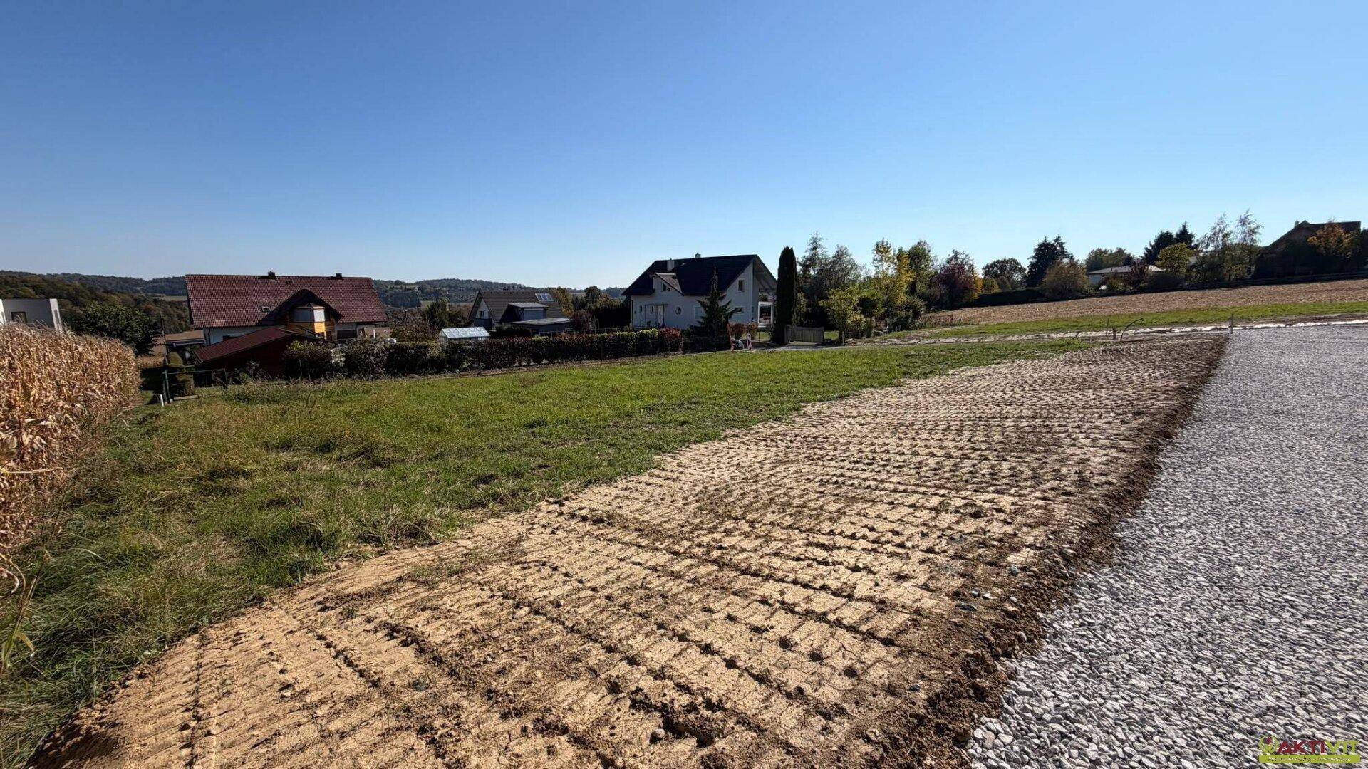 Teilweise vorbereitetes Grundstück mit Schotterweg und Blick auf die umliegende Landschaft.